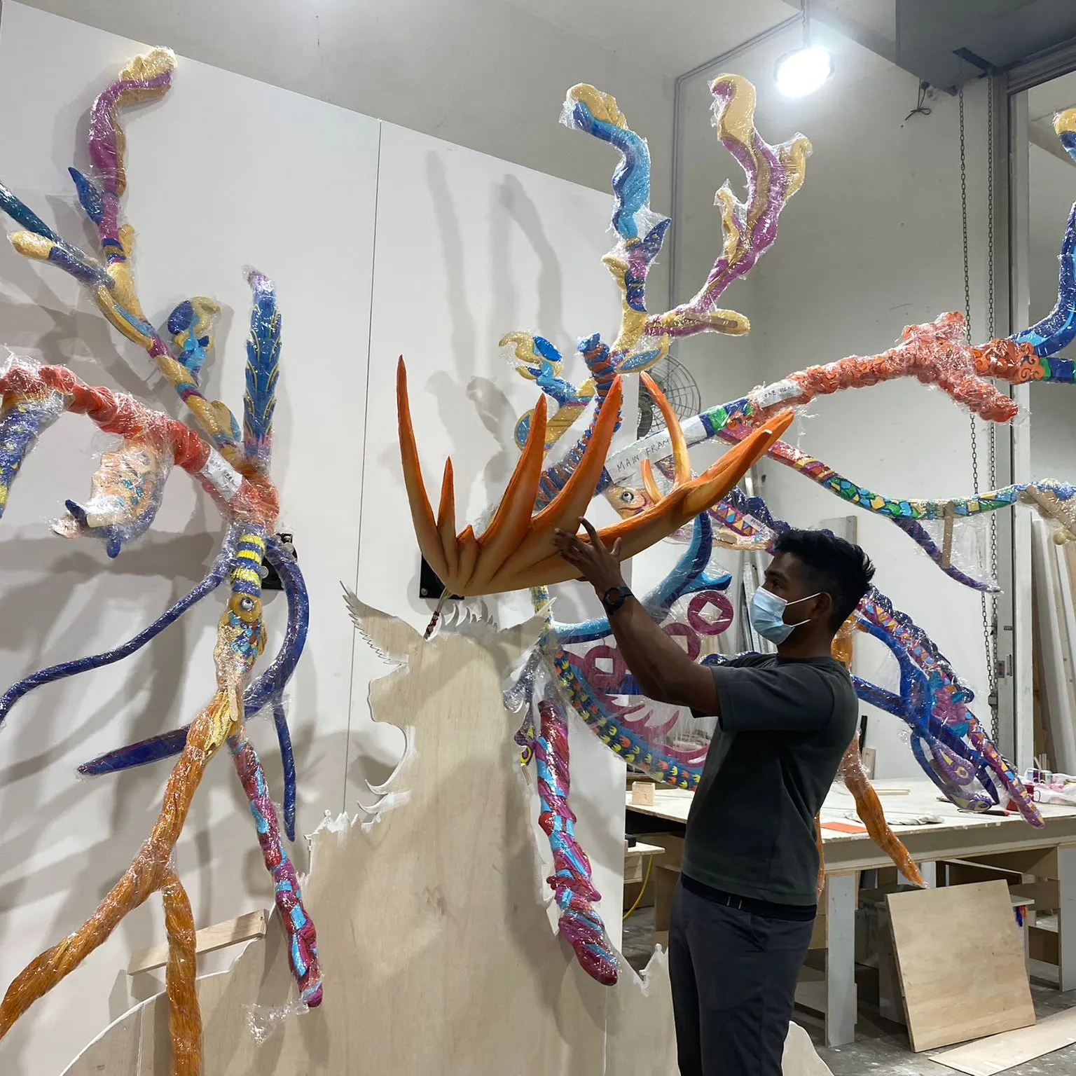 Artist fitting the printed crown piece among the finished antler segments in the studio