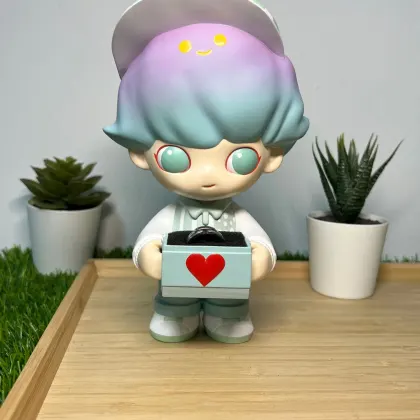 A large collectible-style figure holding an engagement ring box