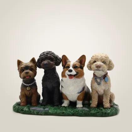 Four hand-painted dog figurines side by side on one grass base