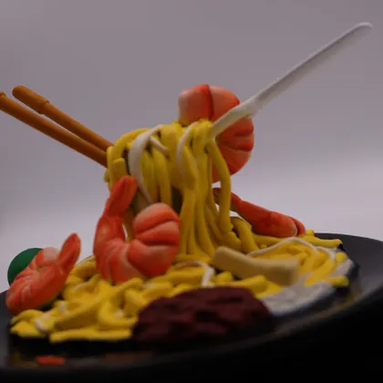 A plate of hokkien mee sculpted and hand-painted, with chopsticks