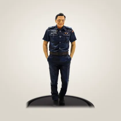 A hand-painted figurine of a man in a navy uniform, hands in his pockets