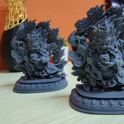 A pair of ornate temple guardian statues, finely sculpted and dark-painted
