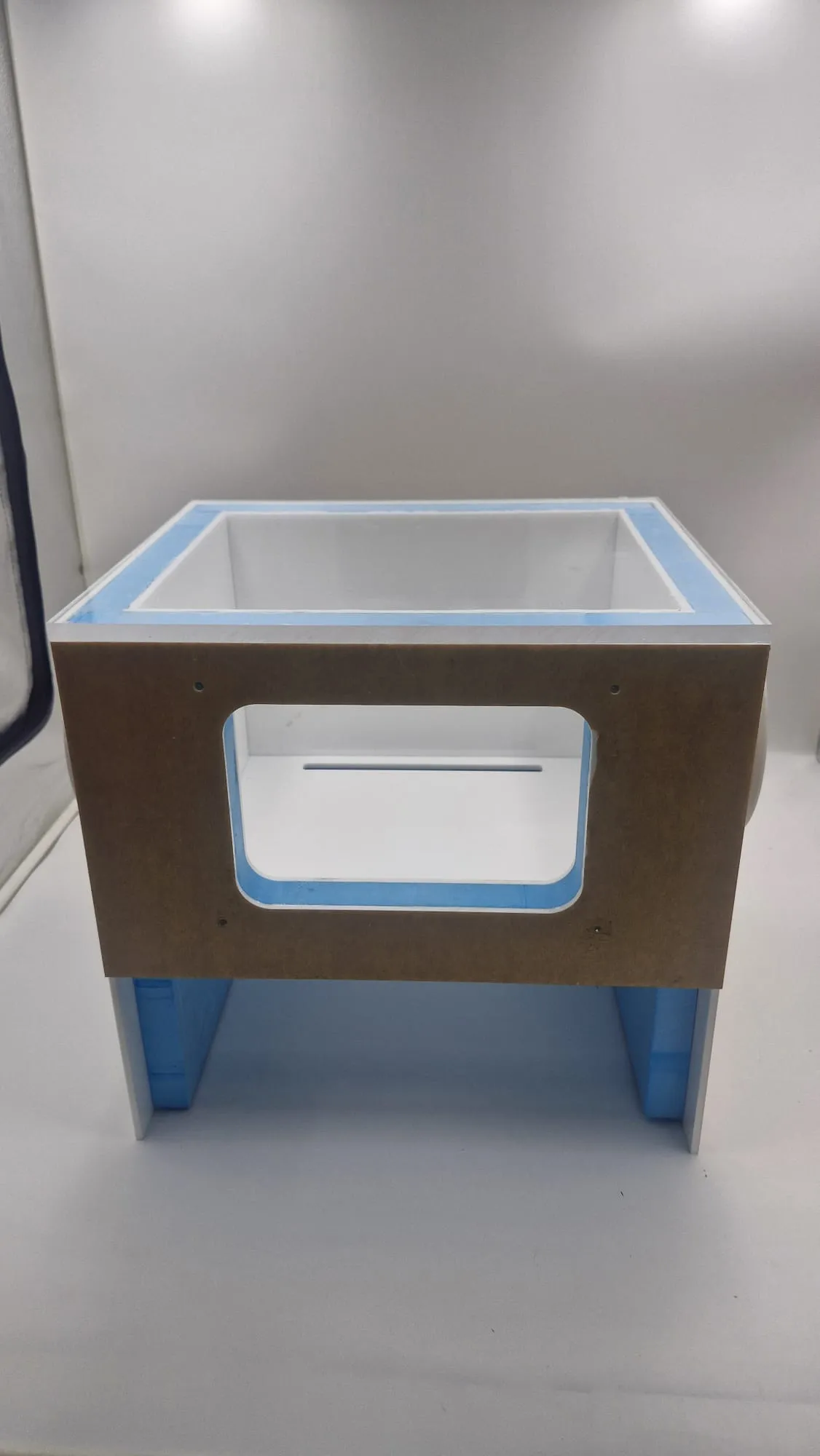 The finished box head-on: the framed viewing window, the white interior behind it and the open stand underneath