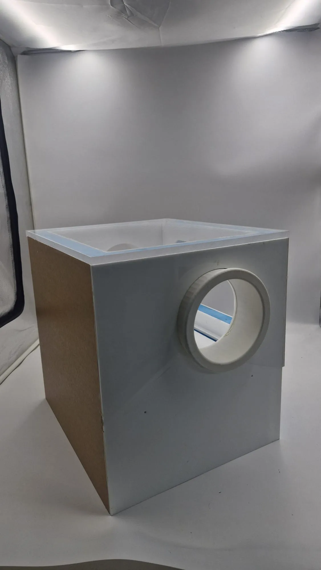 The box from a back corner, a white glove port on one side and a plain panel on the other
