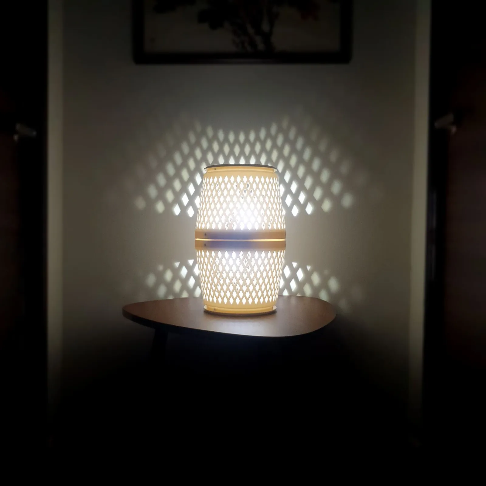 The lit purifier lamp on a small wooden table against a wall, throwing rows of diamond-shaped light on either side