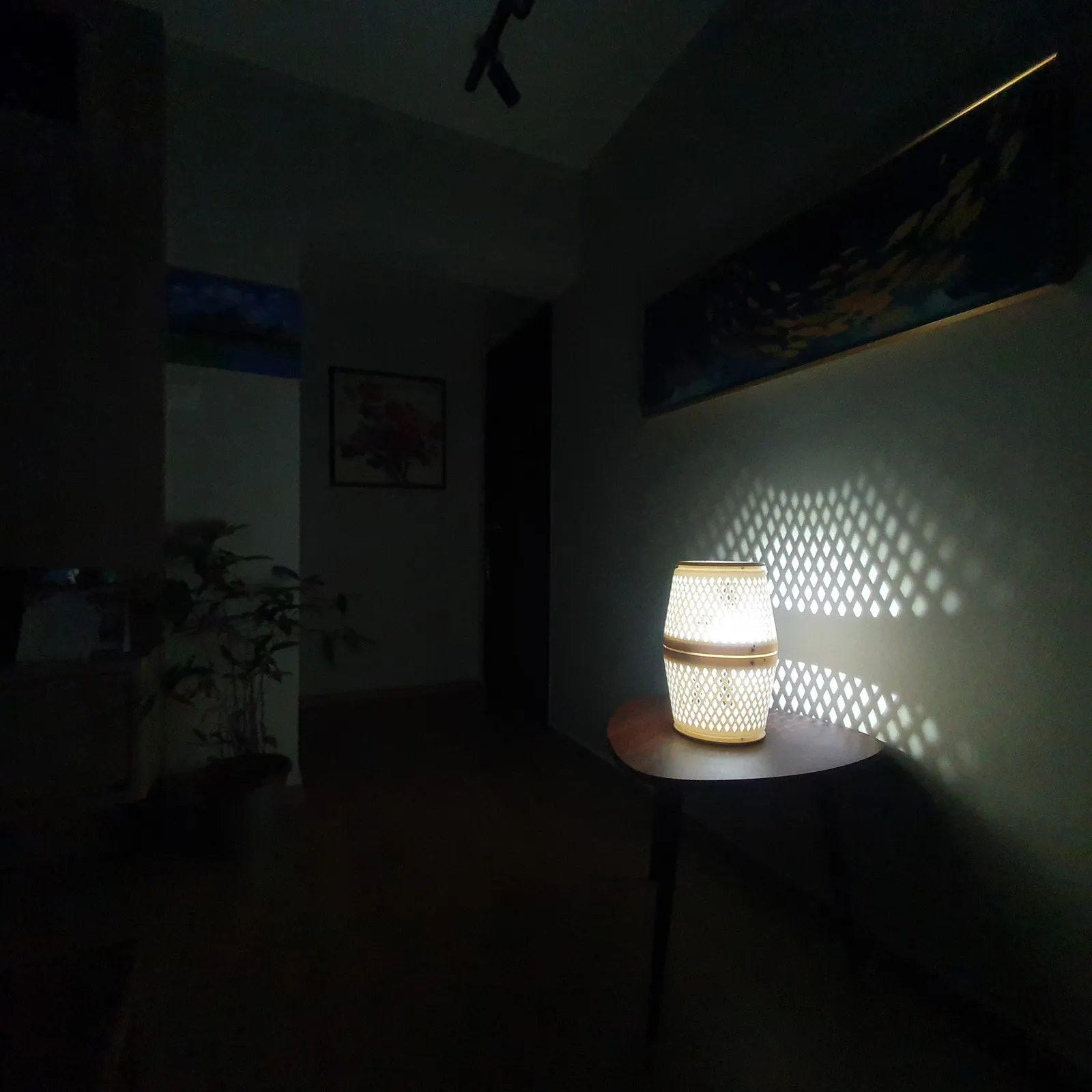 The purifier lamp glowing in a darkened hallway, its diamond pattern spread across the wall beside it
