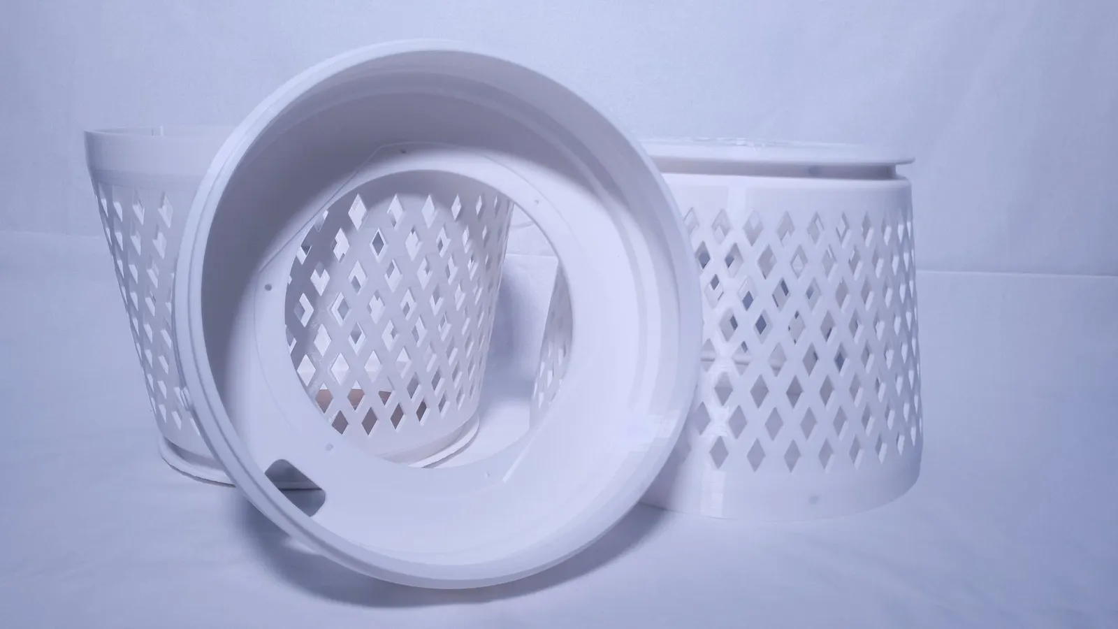 A printed white ring stood on its edge in front of the two diamond-lattice halves, showing the groove that locks them together