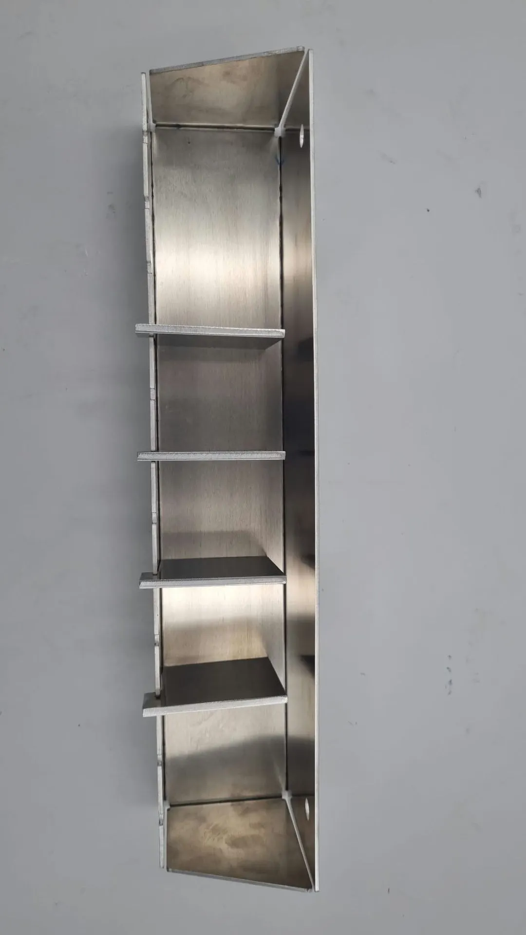 Looking straight down into the holder standing on its end, with the four dividers spaced across the tray