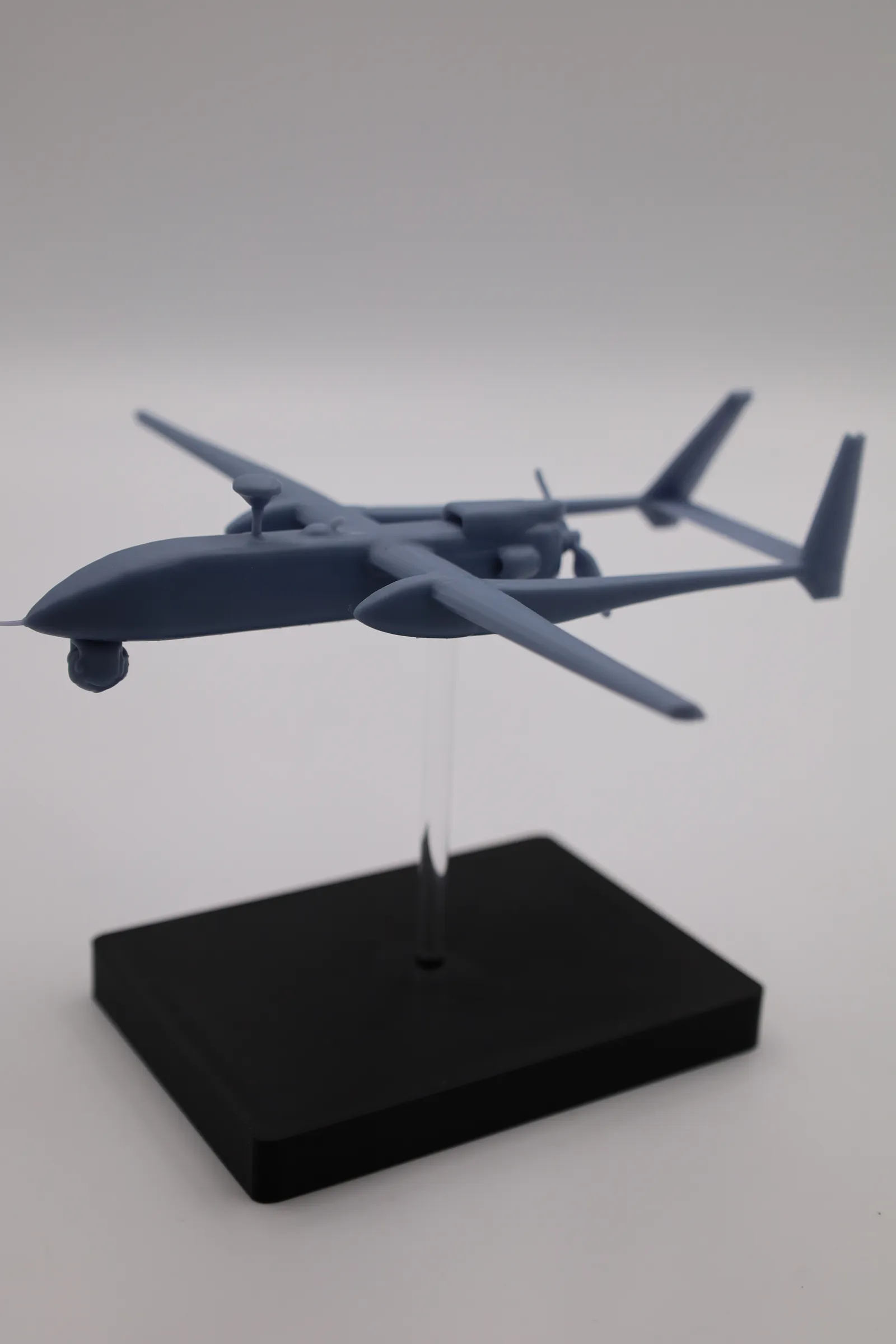 Portrait shot of the finished model in flight on its clear rod, with the black base below