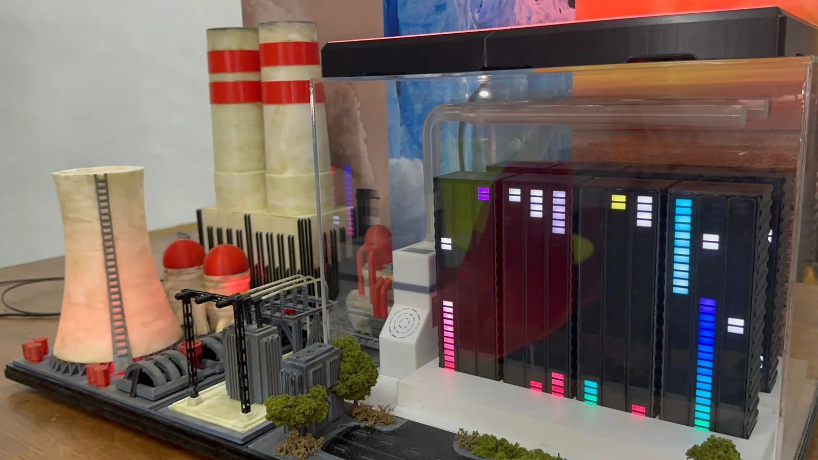 Today's side of the finished model: the glowing cooling tower, red and white chimneys and power station beside server racks with coloured level lights in an acrylic case