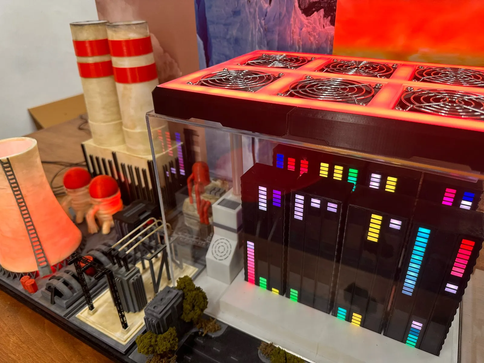 The six-fan panel glowing red on top of the acrylic case, over the server racks and their coloured lights, with the chimneys behind