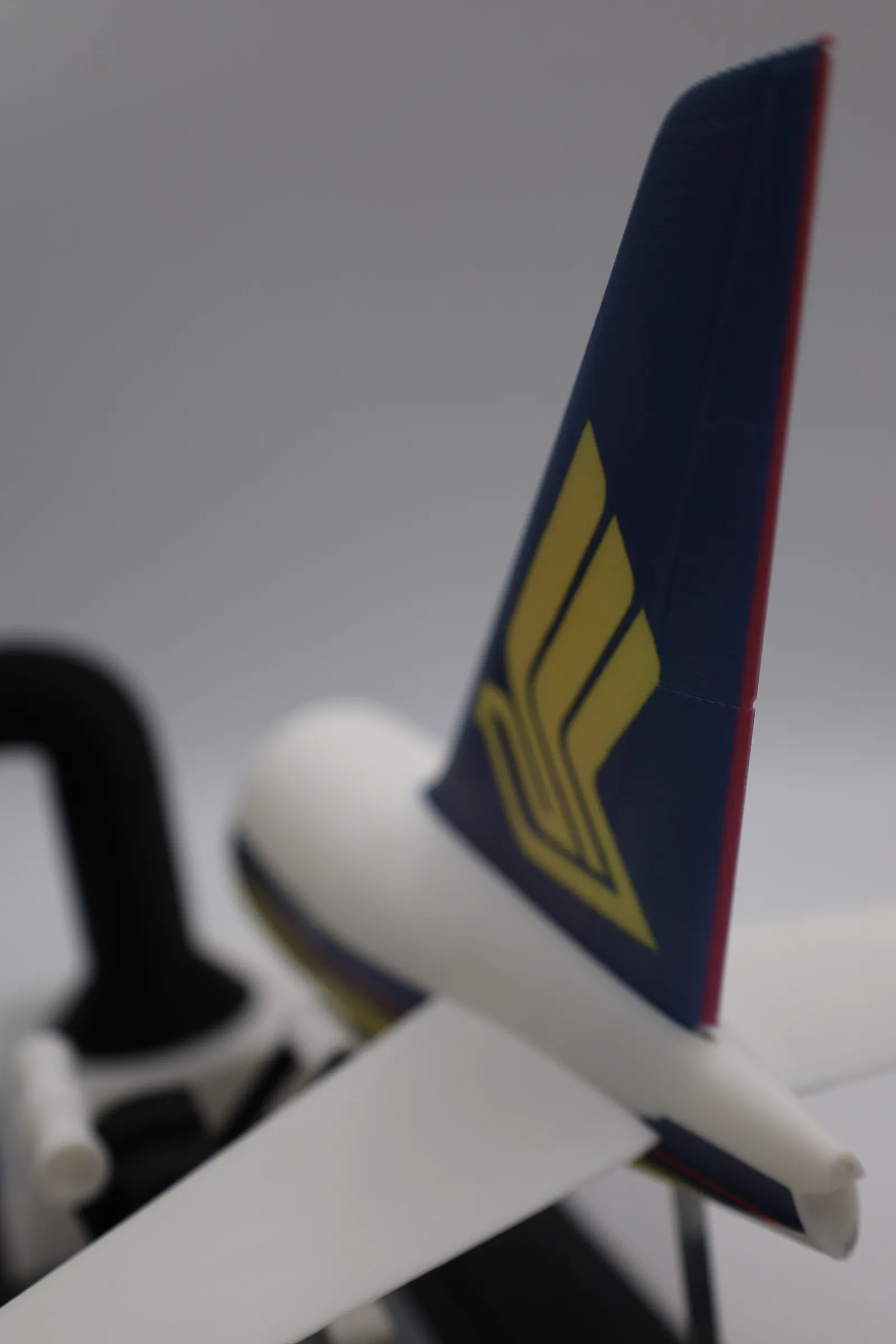 Close up of the printed 787 tail fin in dark blue with the gold Singapore Airlines bird logo