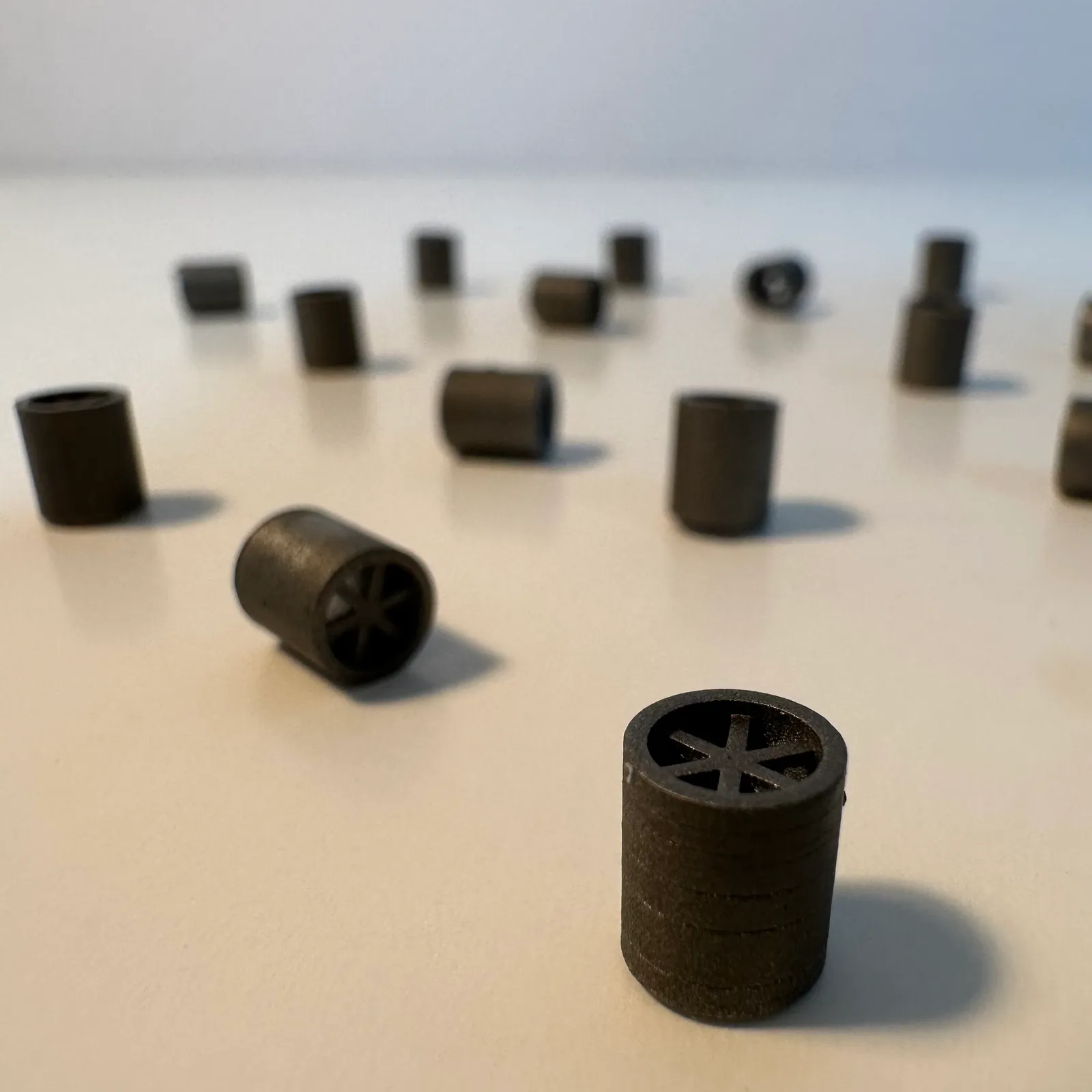 Close-up of one finished spare standing in front, with more of the batch out of focus on the table behind it