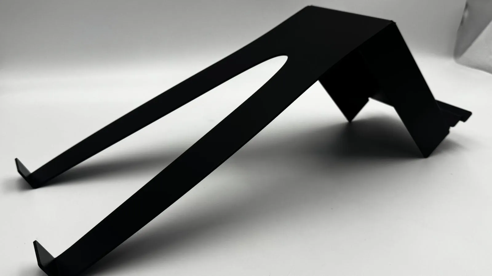 A matt black fin stand on its own: two long legs splitting from the slatwall shelf
