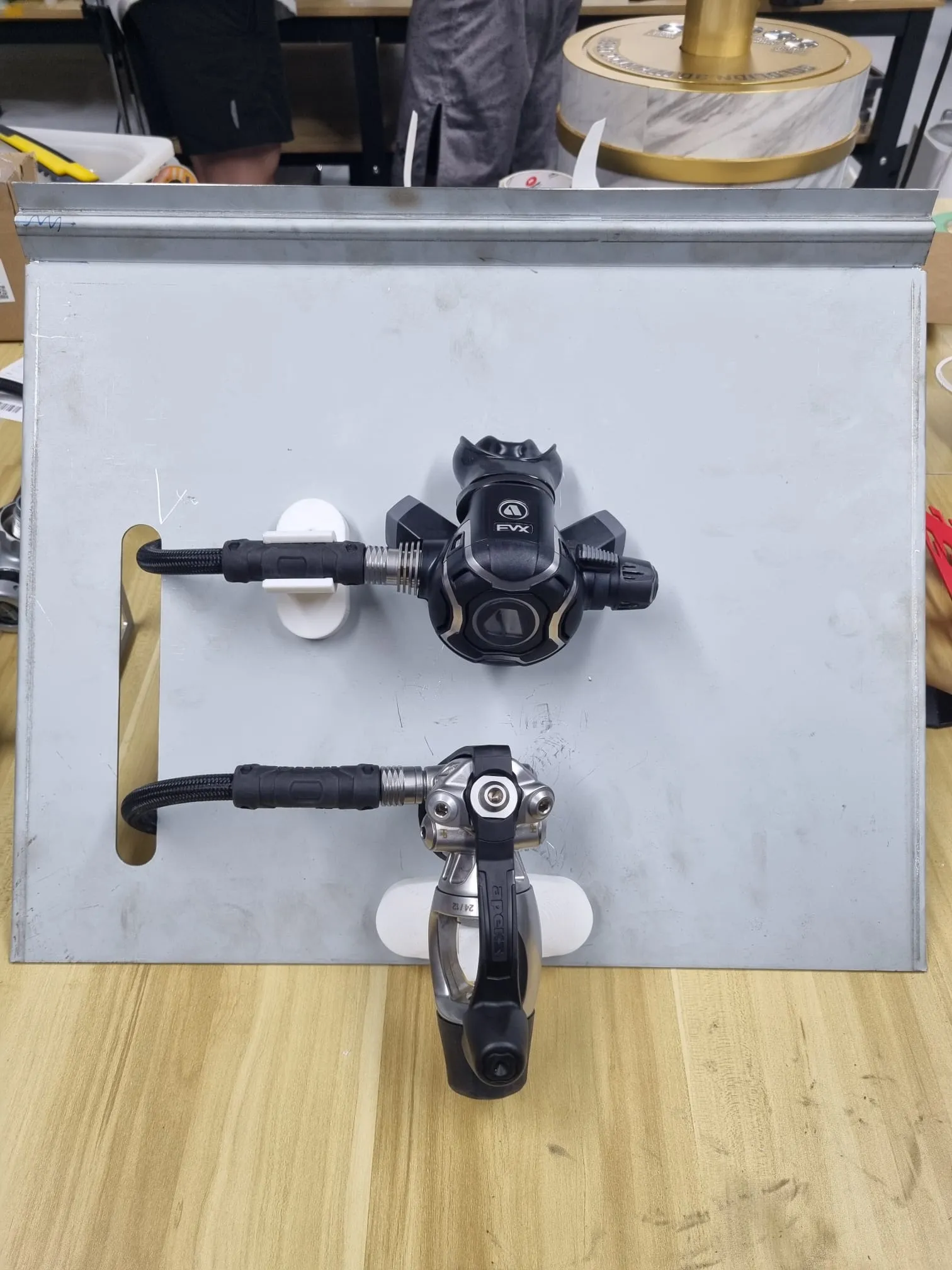 The steel prototype panel holding a second regulator on white printed holders, its hose looped through the slot