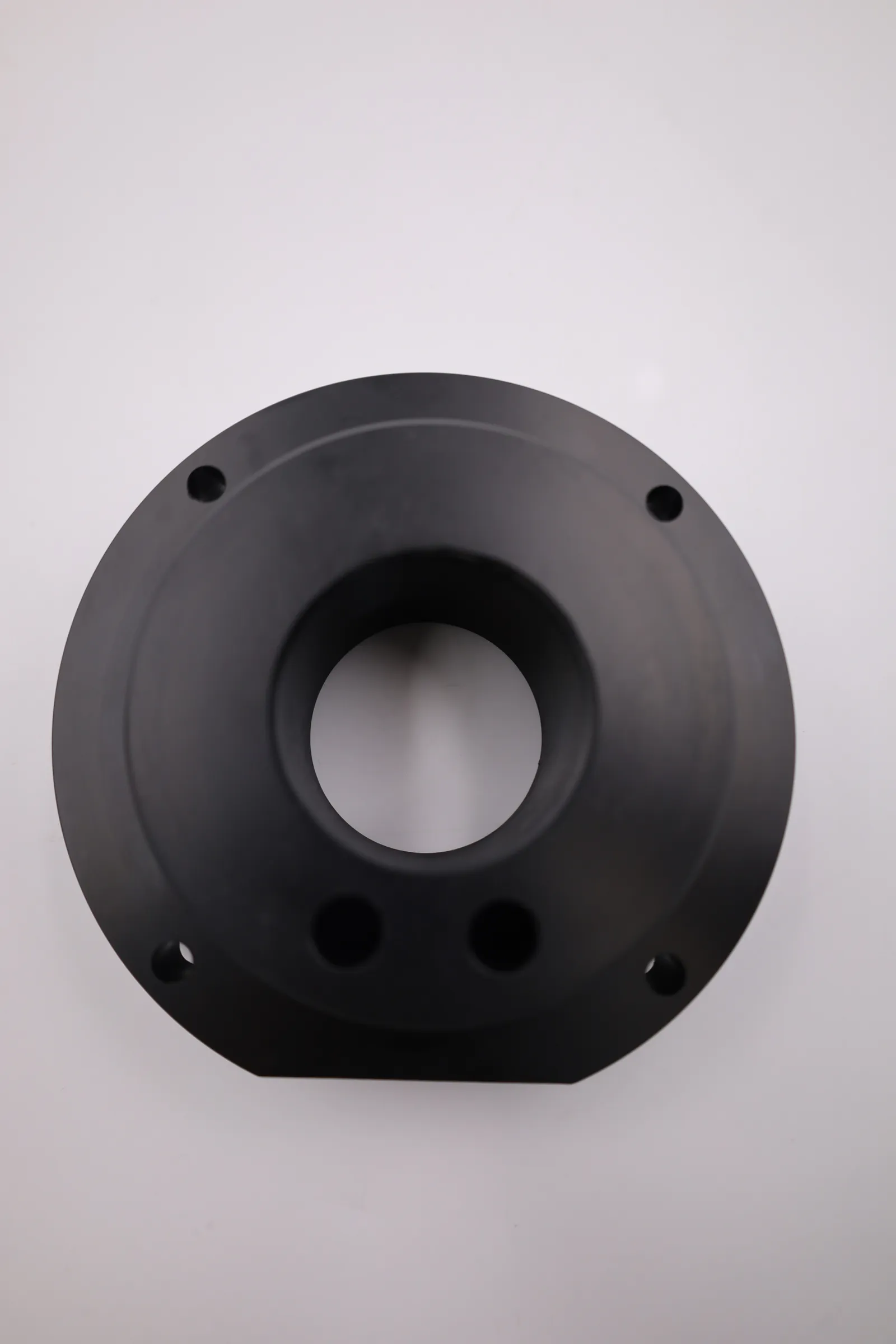 A black POM-C fuel filling lid seen face-on, showing the centre bore, two smaller holes below it and four bolt holes around the flange