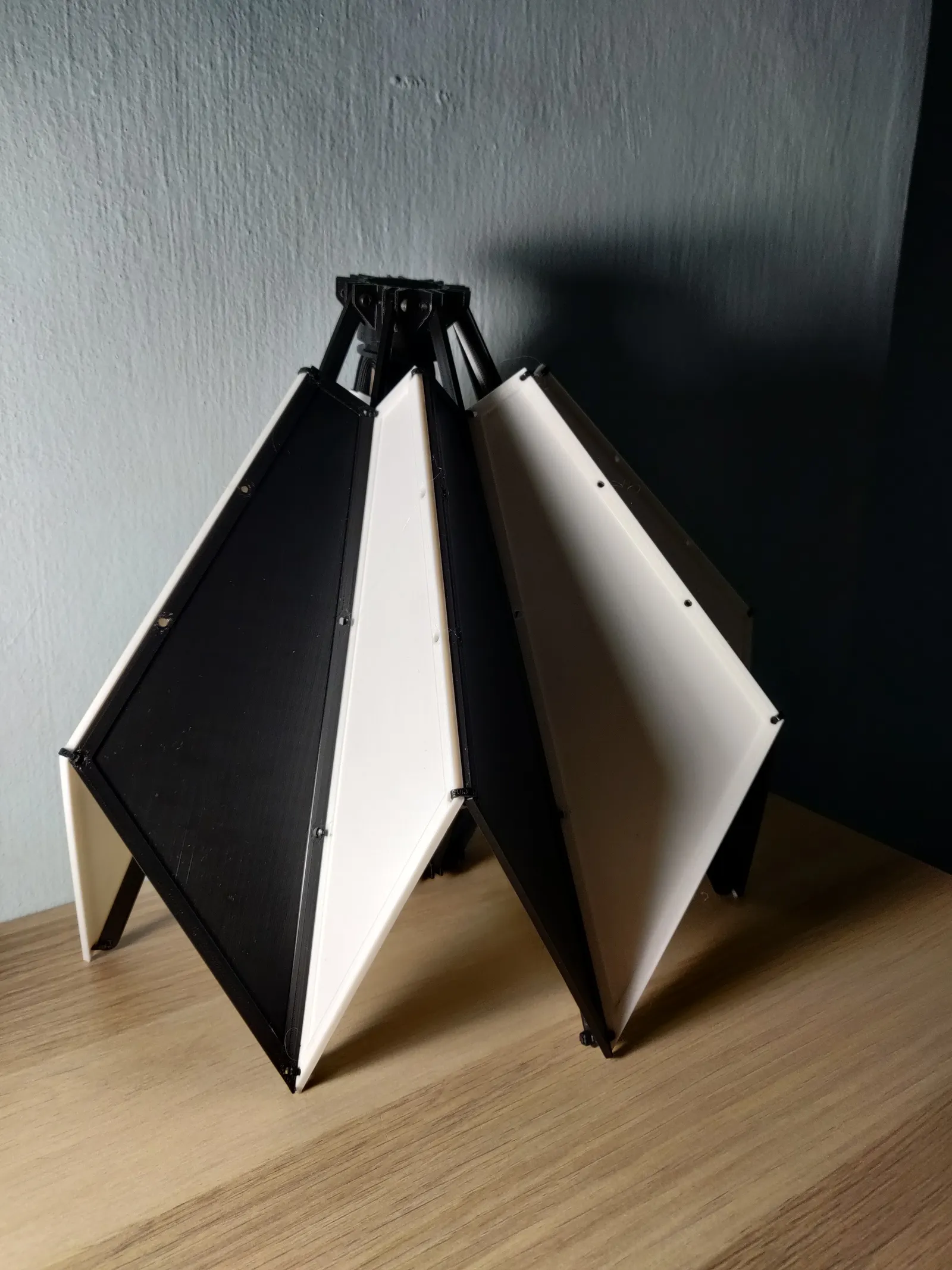 The prototype from a front corner, black and white panels angled down from the black hub at the top