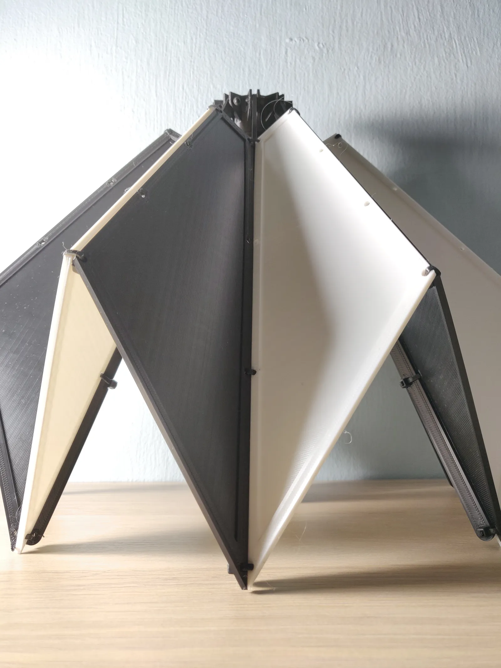 The prototype head-on against a white wall, a white panel in the middle between two dark panels