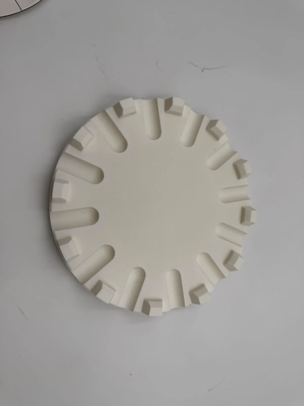 The printed holder from above, showing the 12 lift slots running in from the rim between the 12 alignment blocks