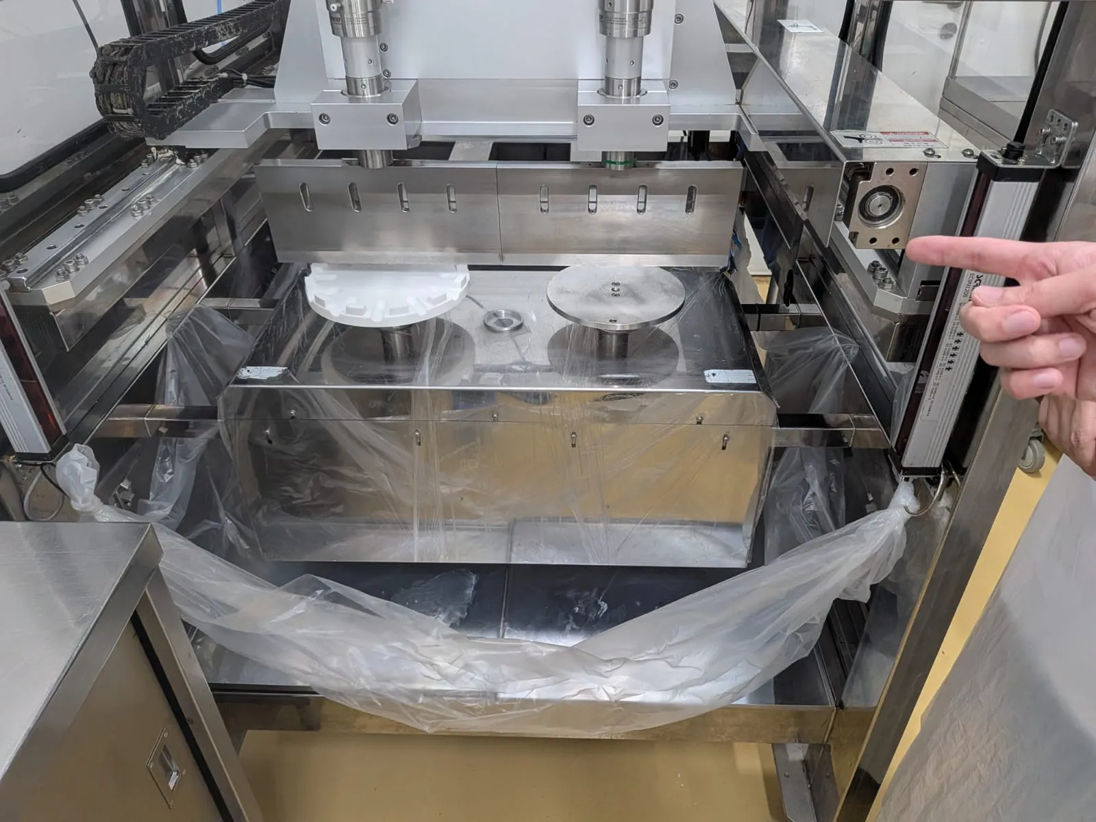 Fit test on 6 July: the white printed holder mounted on the client's cake-cutting machine beside its metal turntable