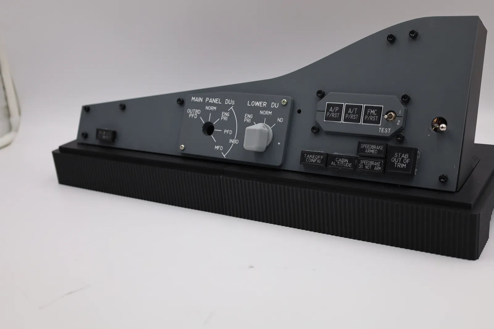 The enclosure with the cover off: the grey control panel tilted back on its black support, above the ribbed black base