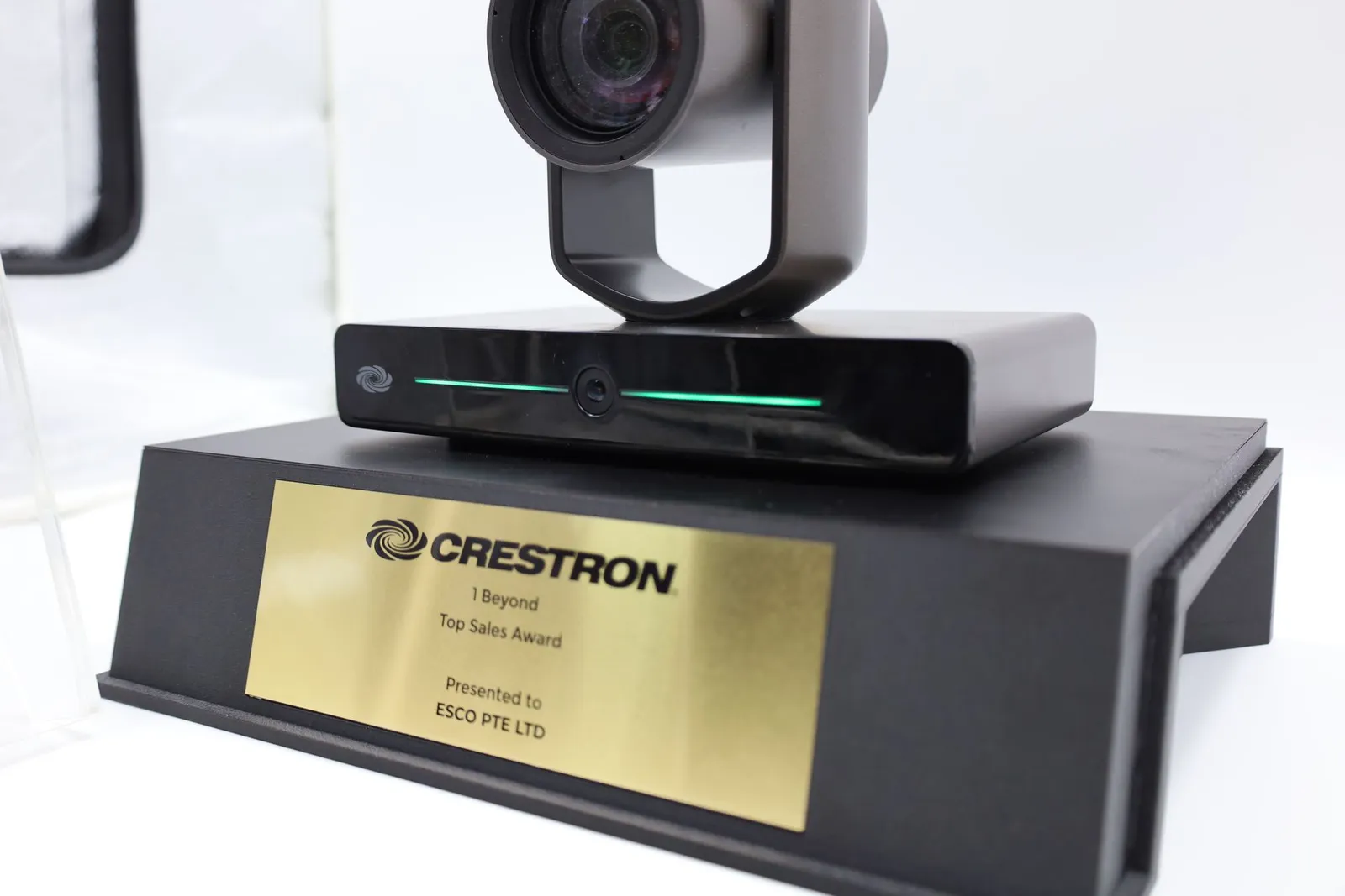 The camera on its black base with a green LED line lit across the front, above the gold nameplate