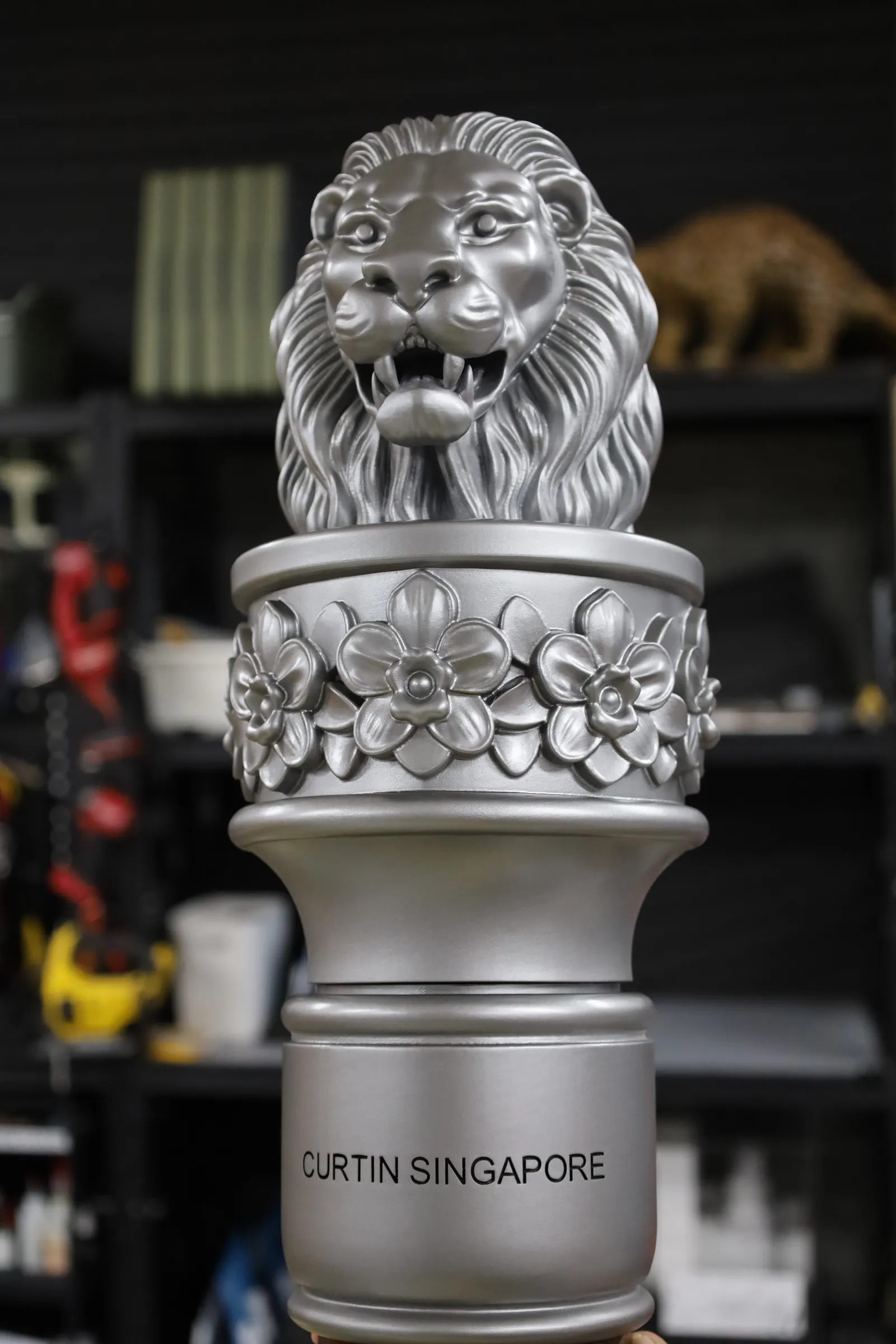 Front of the finished mace head: the silver lion, the orchid collar and CURTIN SINGAPORE in black on the ring below
