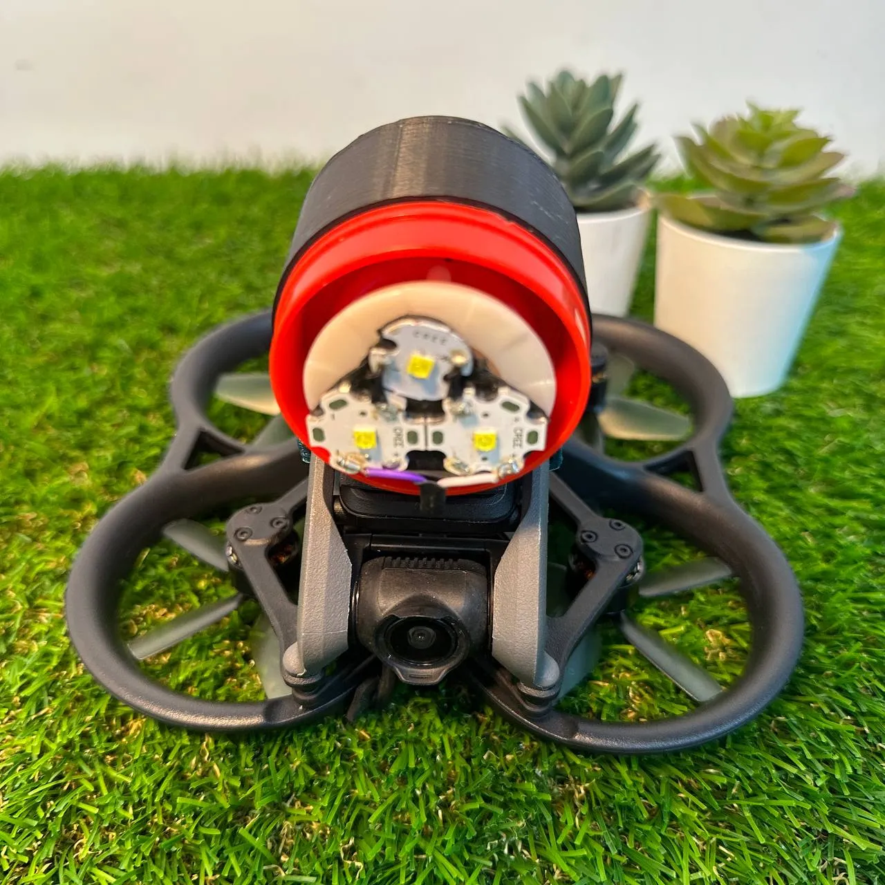 The drone head-on, with the round spotlight and its three LEDs sitting directly above the camera