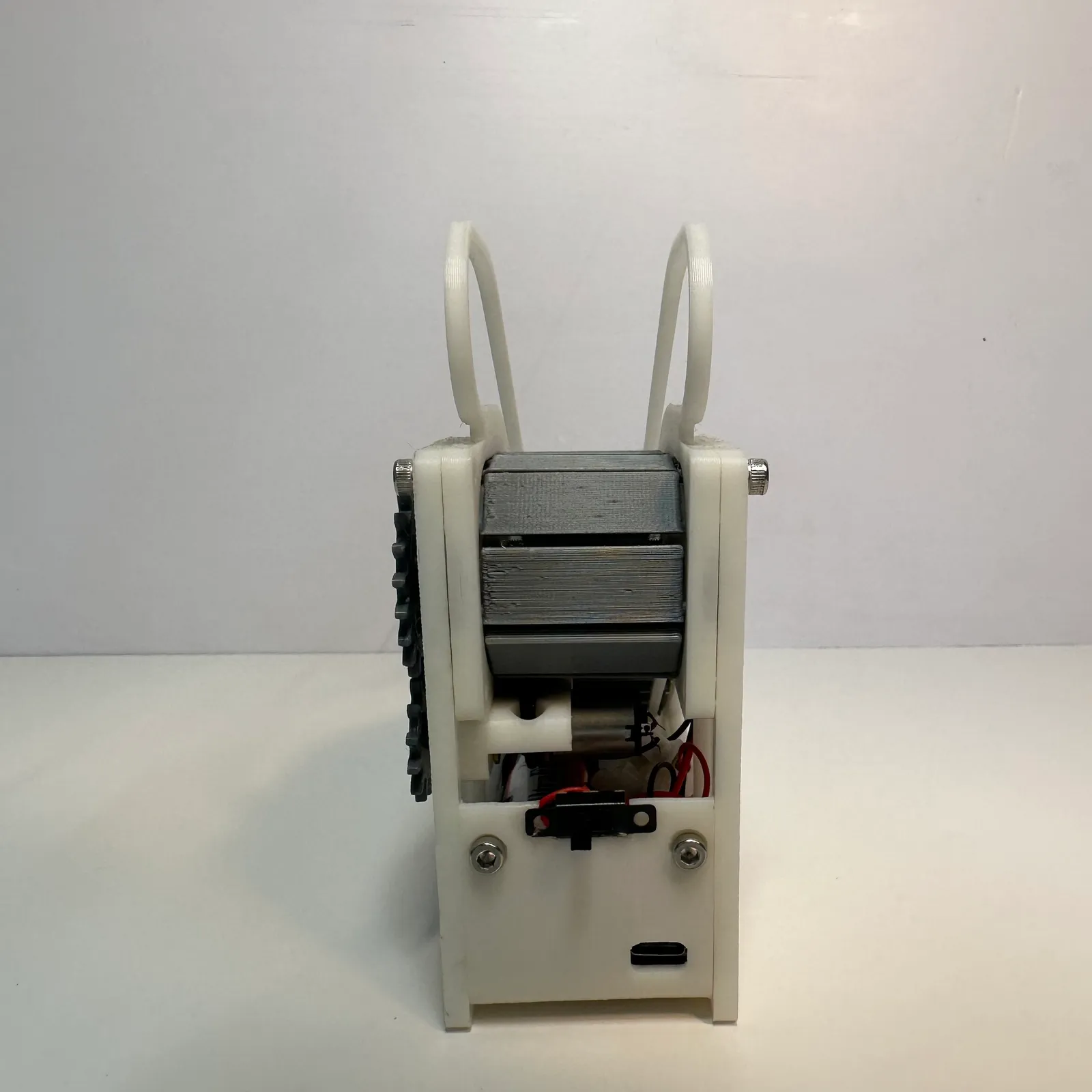The back of the escalator model: the step chain wrapped round the top, the motor and wiring underneath, a slide switch and a USB-C port in the white end panel