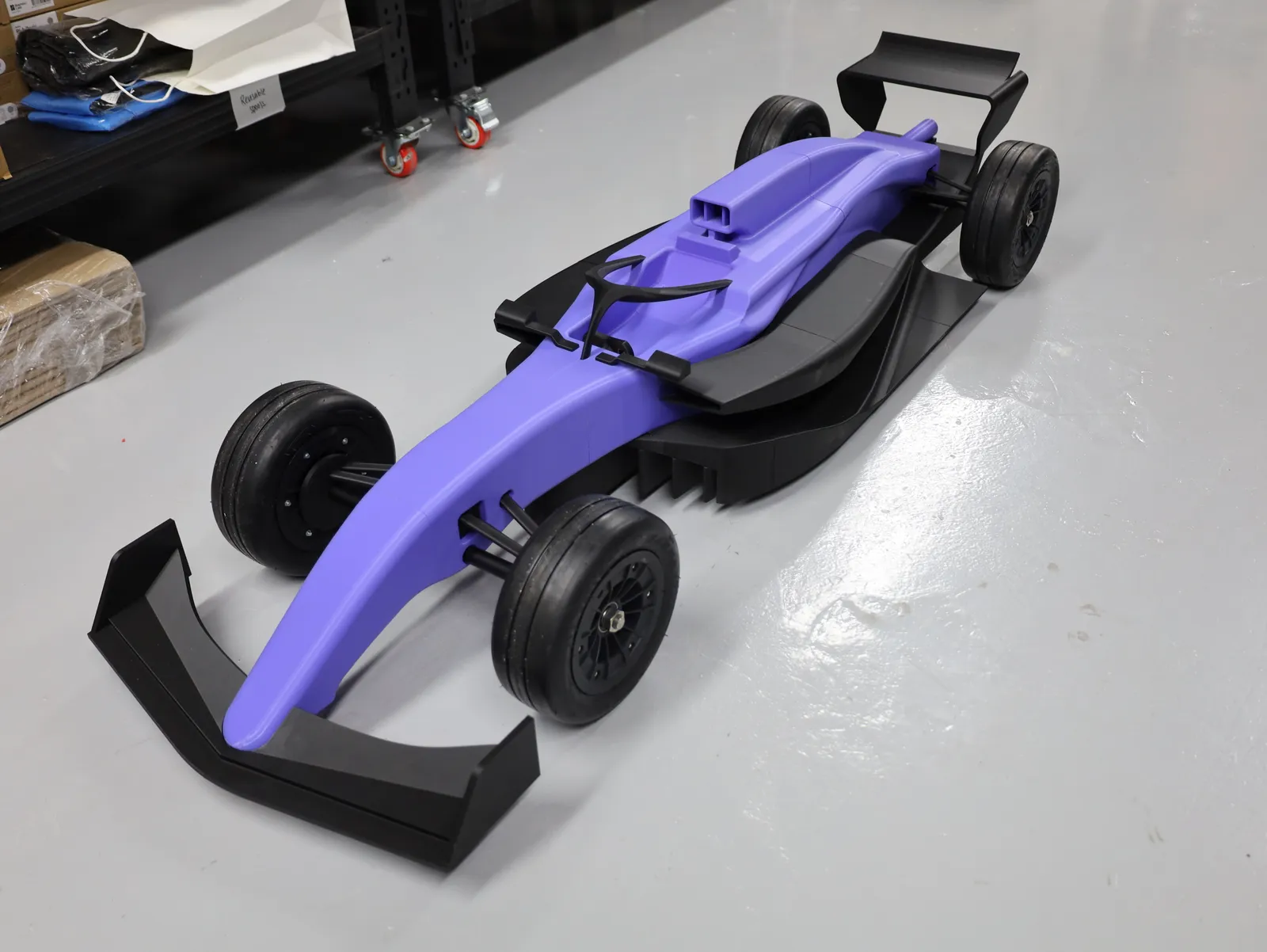 The finished show car on the studio floor from above at an angle, showing the full length from front wing to rear wing