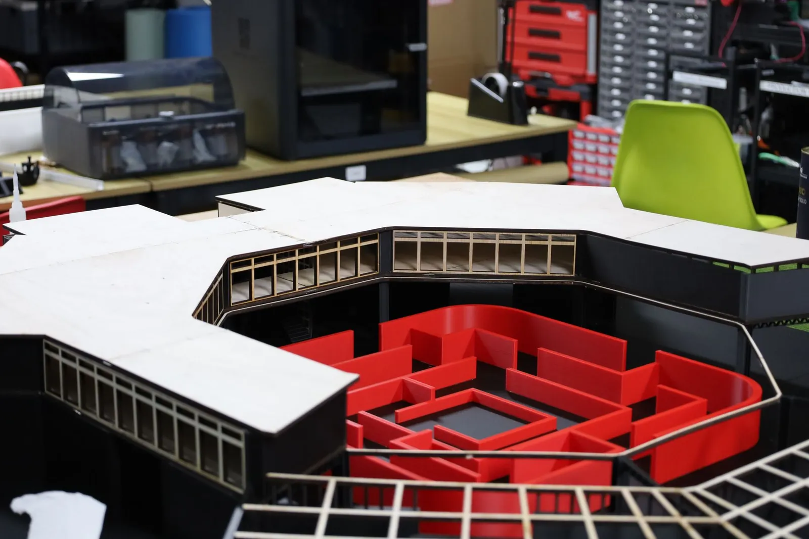 Close-up of the upper level: plywood window frames along the courtyard side of the roof, above the red maze
