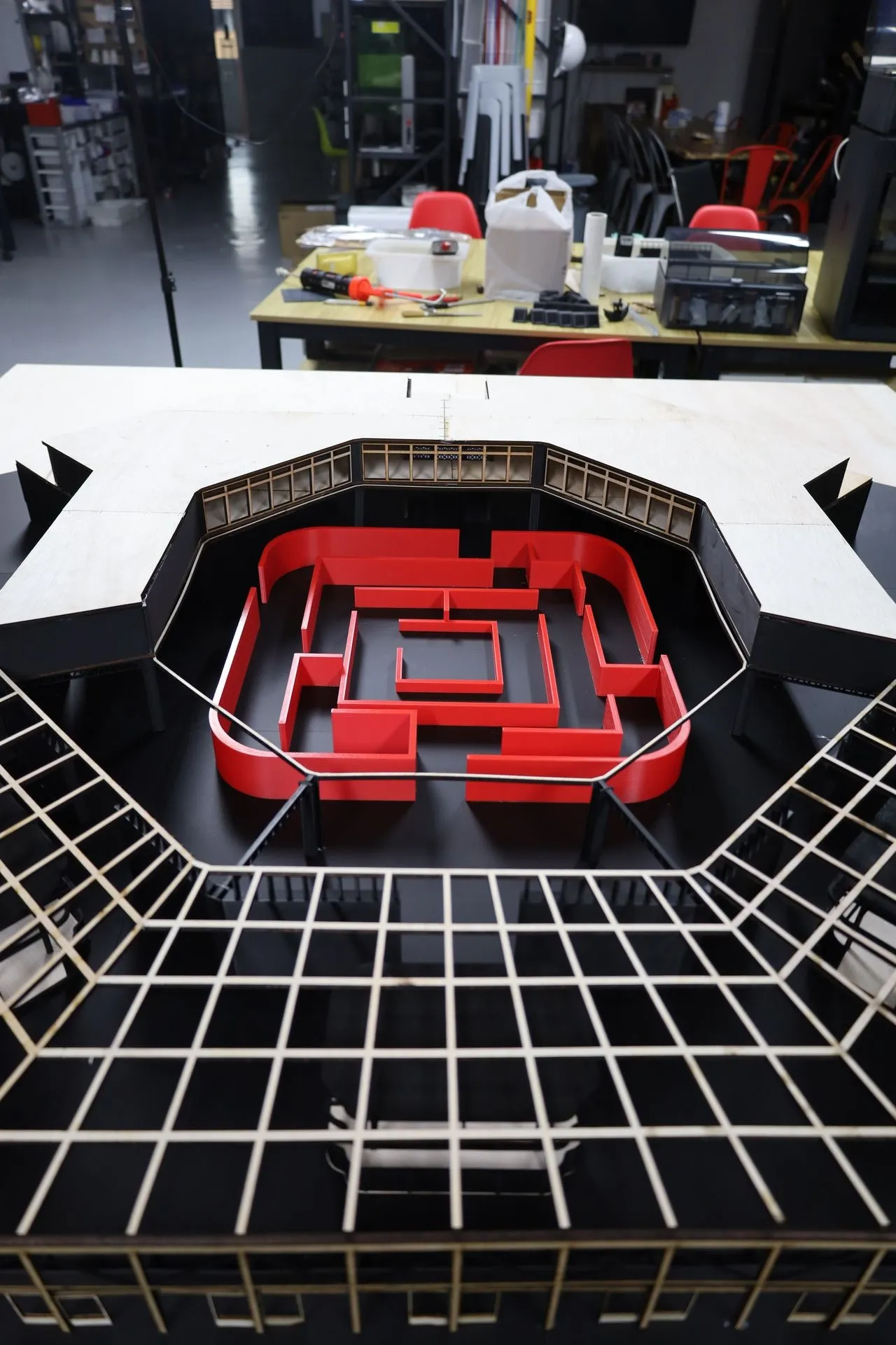Looking across the open roof grid into the courtyard, with the red maze ringed by a plywood rail