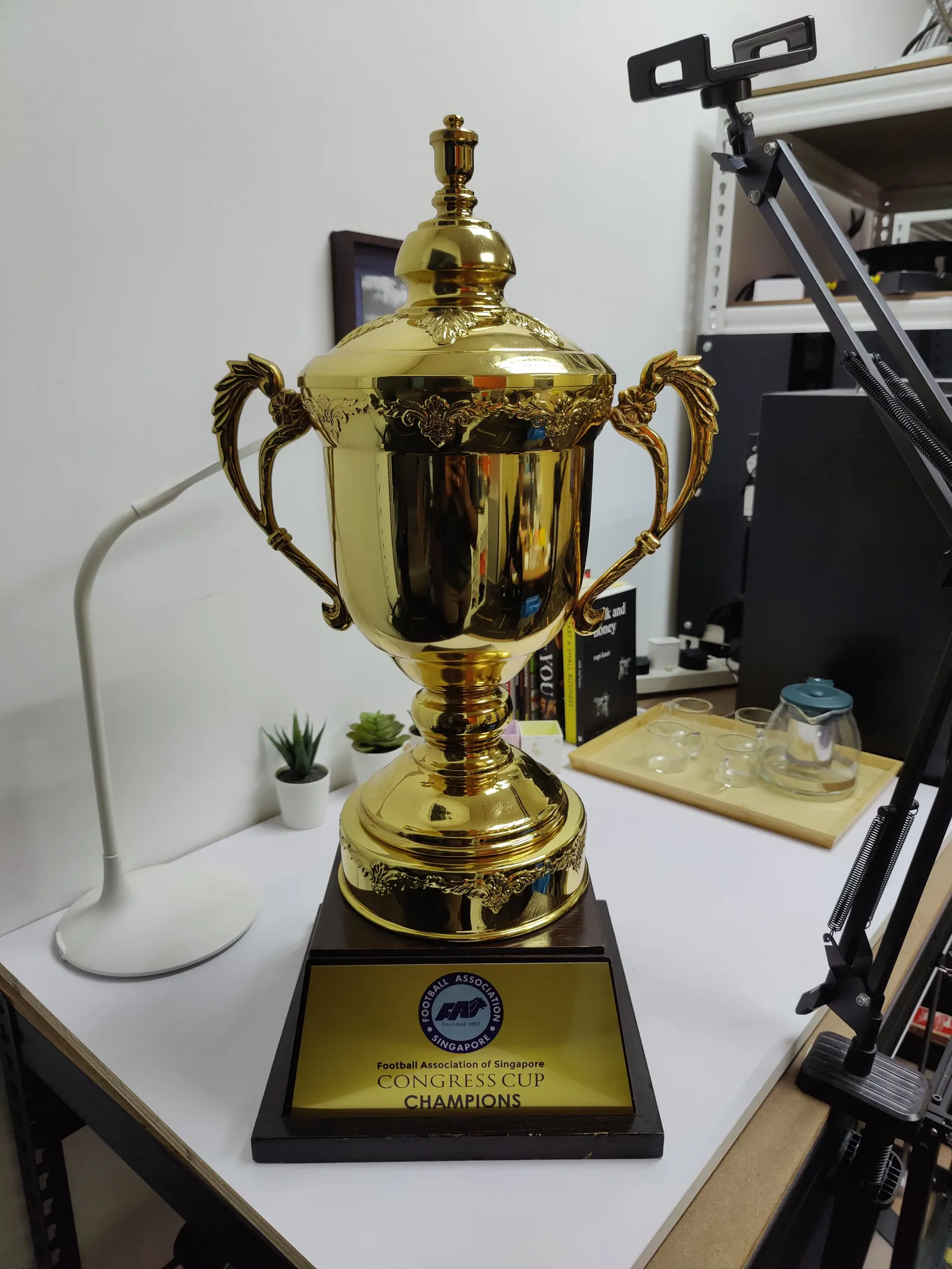 The Football Association of Singapore's original Congress Cup in polished gold metal on a dark base with a plate reading CONGRESS CUP CHAMPIONS, shown as the client's reference, not our work