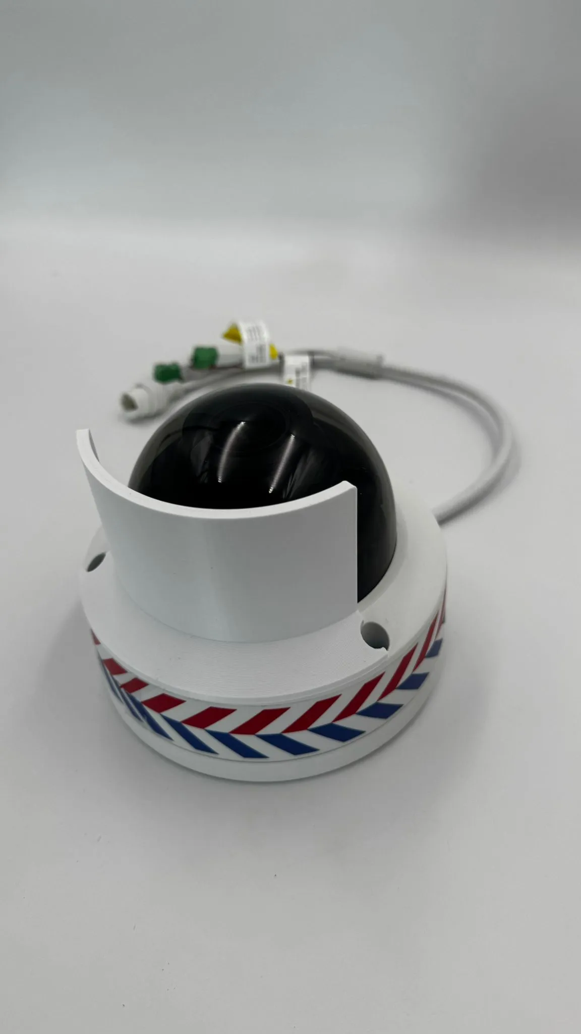 The camera from the front with the white shield wrapped around one side of the black dome