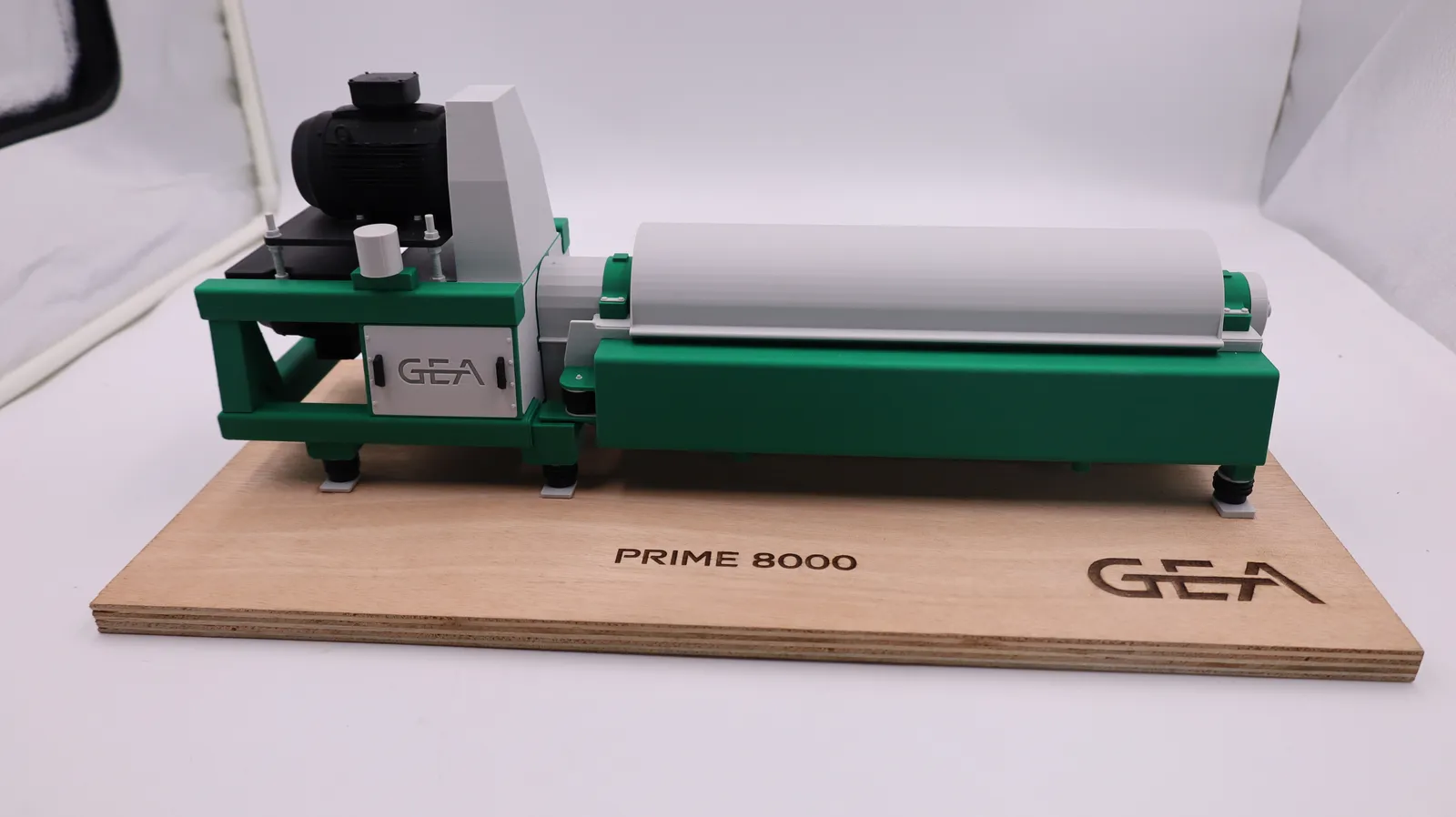 The finished CF-8000 decanter model from the front: green frame, light grey drum cover and black motor on a plywood base engraved PRIME 8000 and GEA