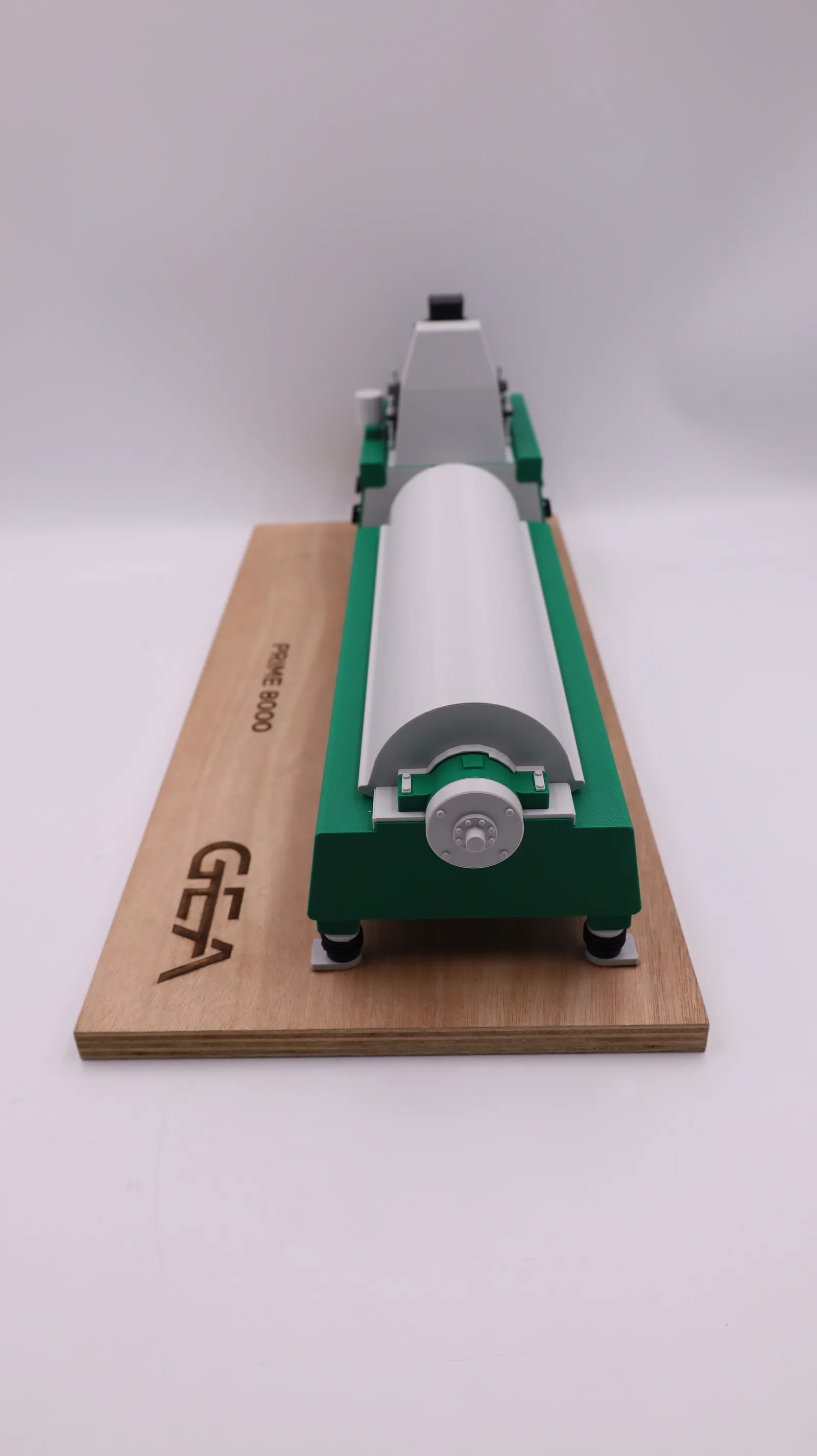 The decanter model seen end-on down the length of its drum, with the engraved GEA logo on the base below