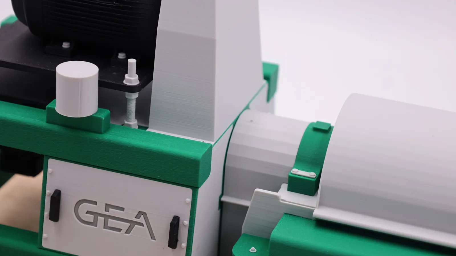 Detail of the printed GEA panel on the frame, with its small handles and bolt heads, beside the drum housing