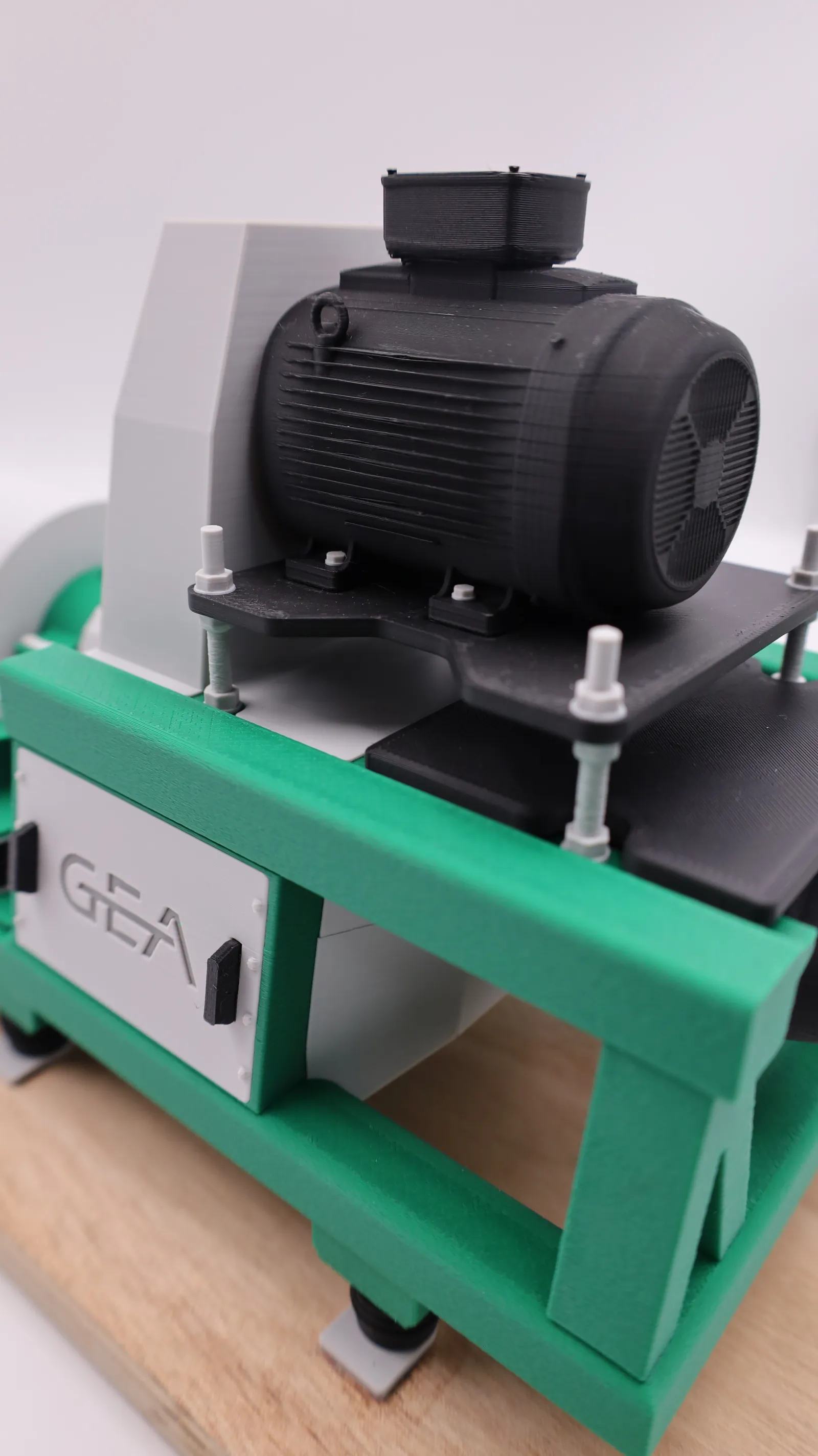 Close up of the black printed motor with its cooling fins and fan cover, sitting on the green frame