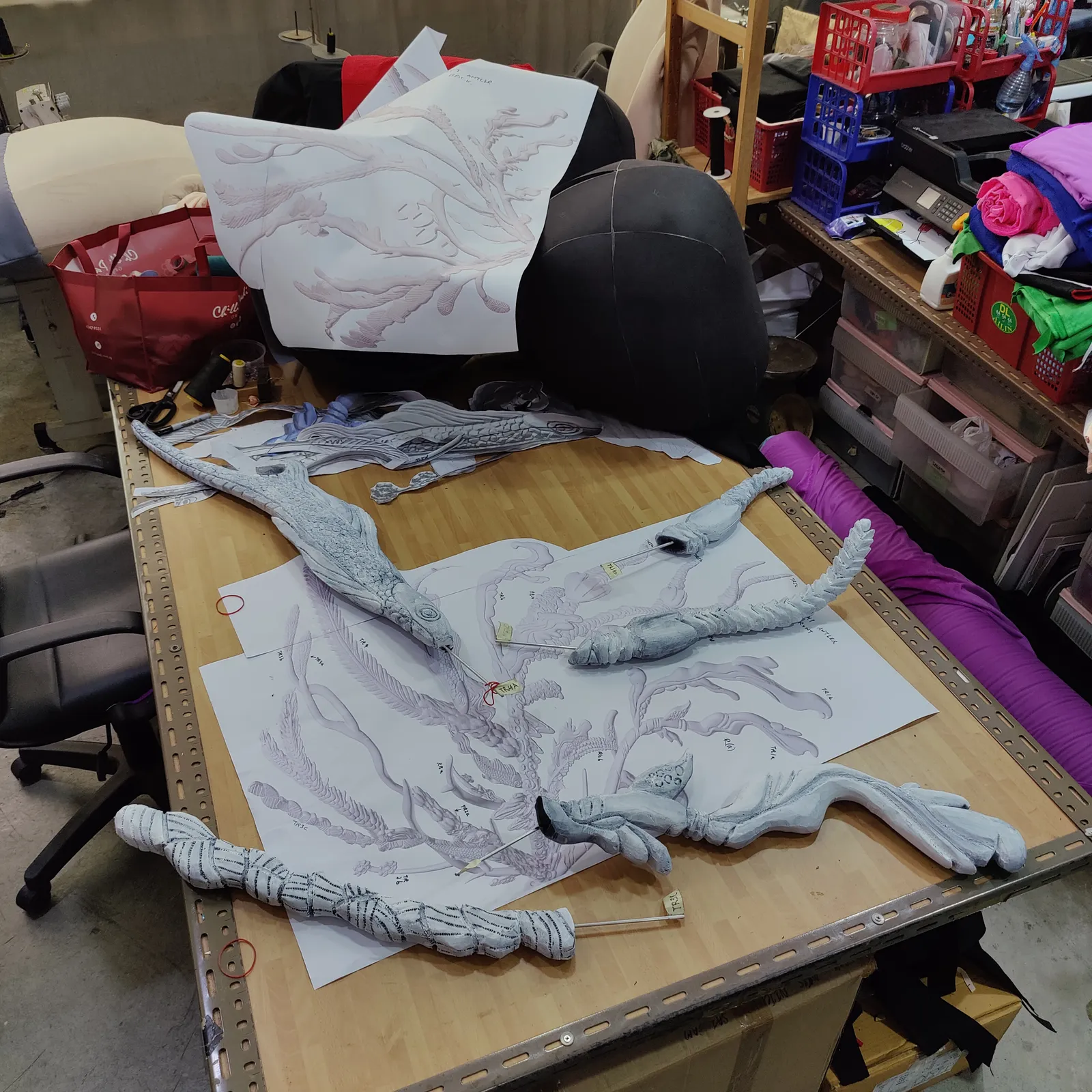 Grey 3D printed antler segments laid out on a workbench in the studio