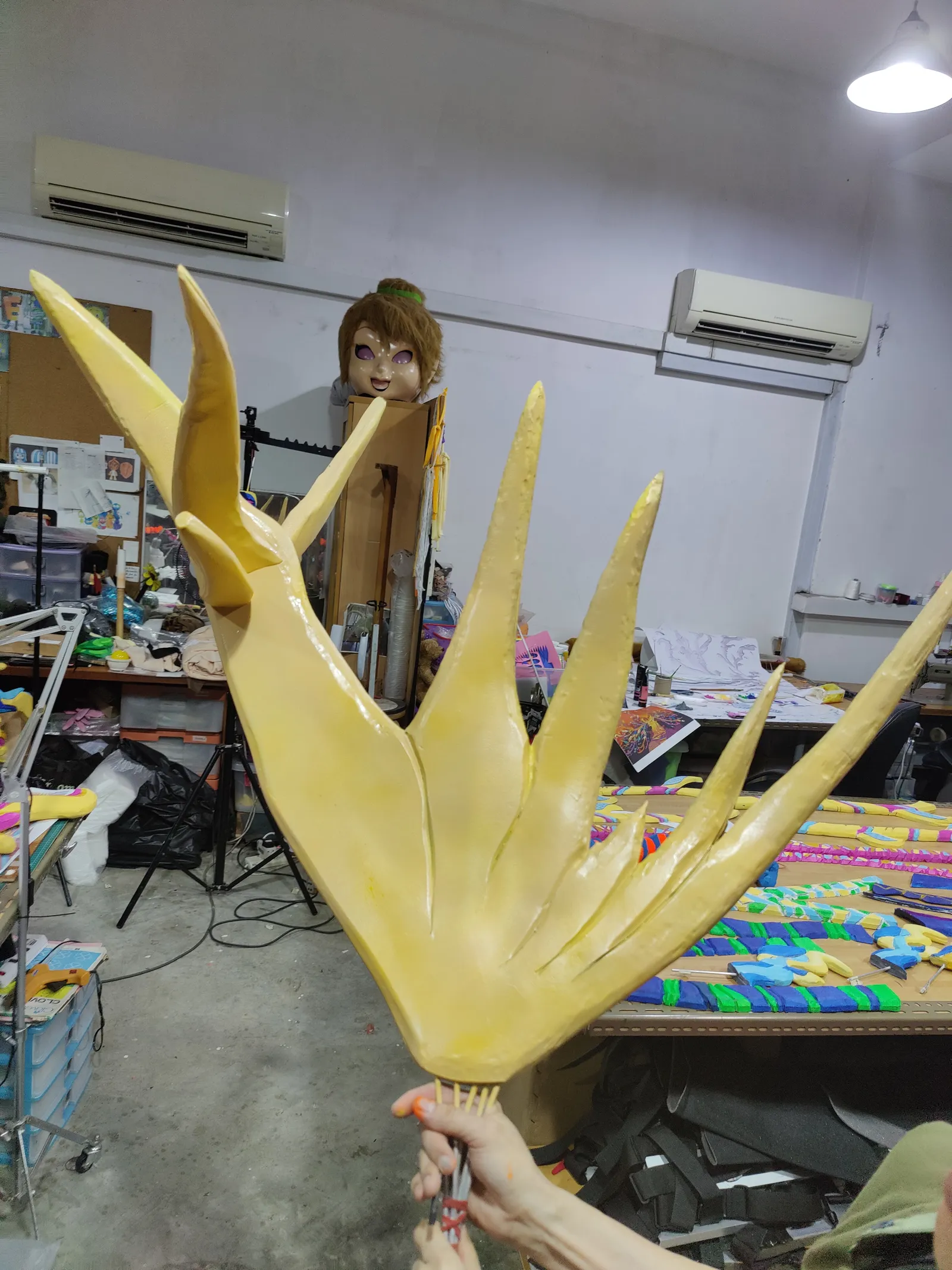 A large yellow printed tine with long pointed spikes, held up in the studio