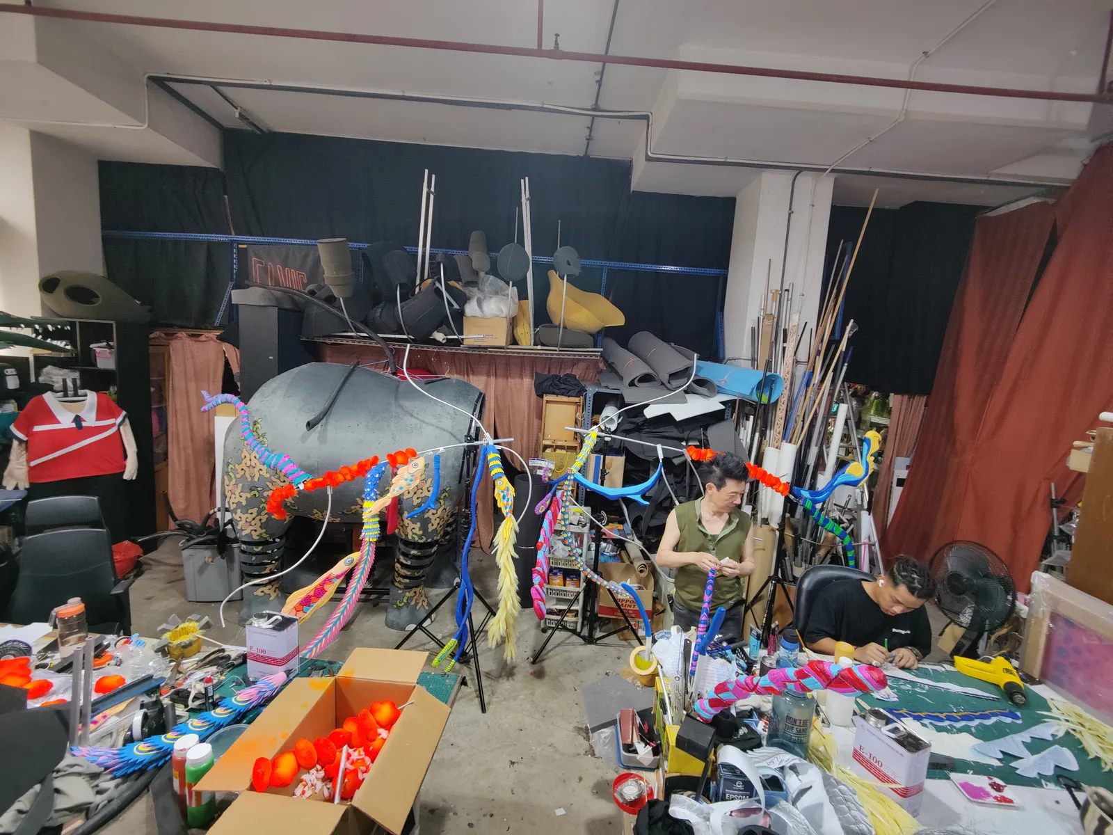 Our team painting antler branches in the studio, painted parts standing on racks around them