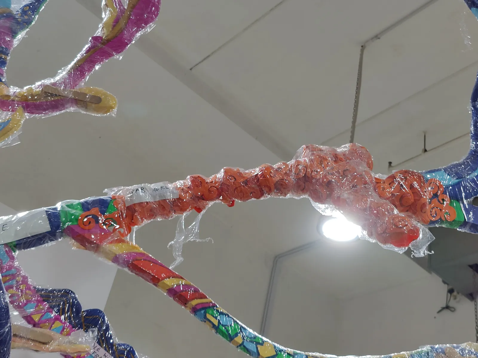 Painted branches wrapped in clear film, seen from below