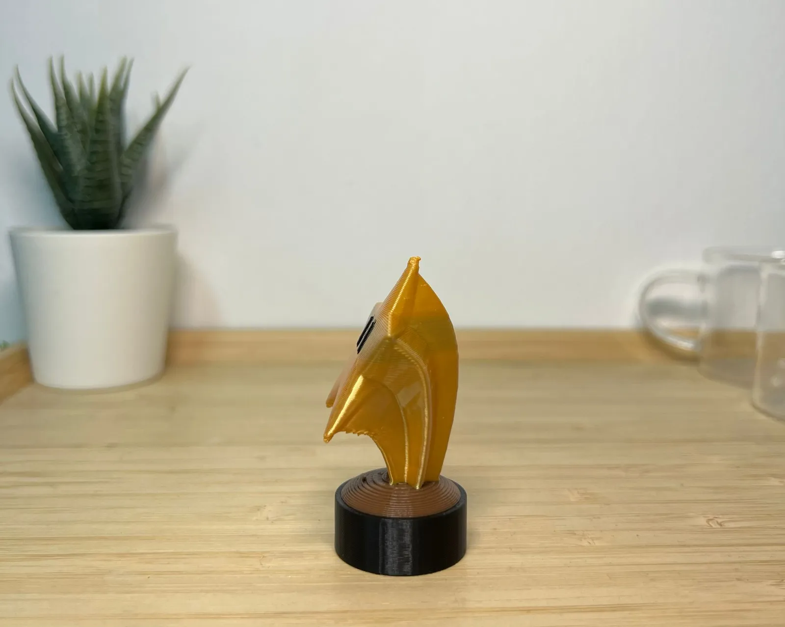 Side view of the finished gold star trophy, showing the depth of the printed star and its tapered stem above the round base