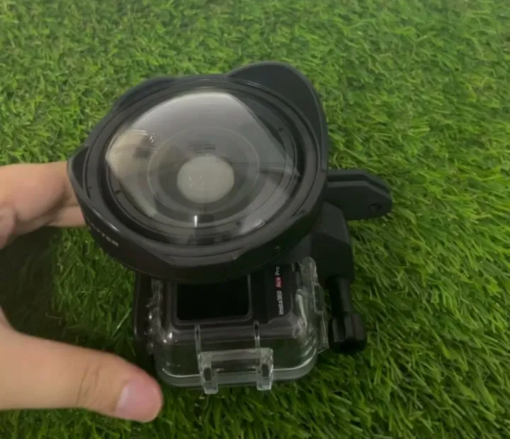 The customer's wet lens mounted on the black 3D printed bracket over the front of his clear action camera dive housing, on artificial grass