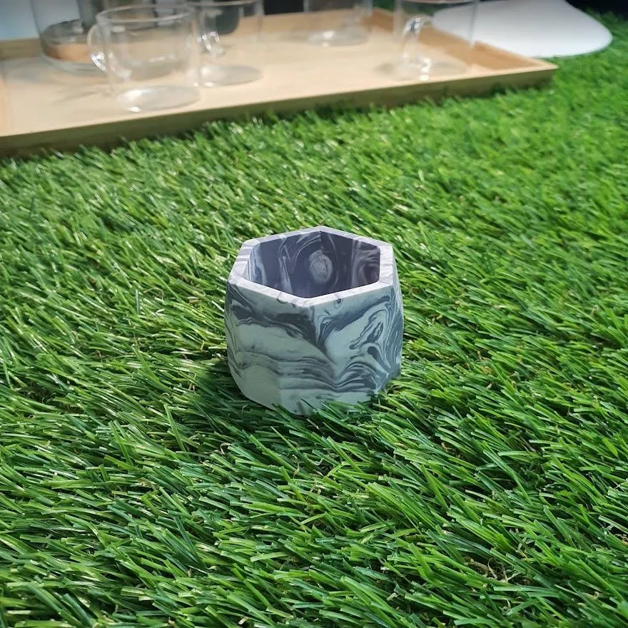 The same hexagonal planter cast in Jesmonite with a dark grey and white marble swirl