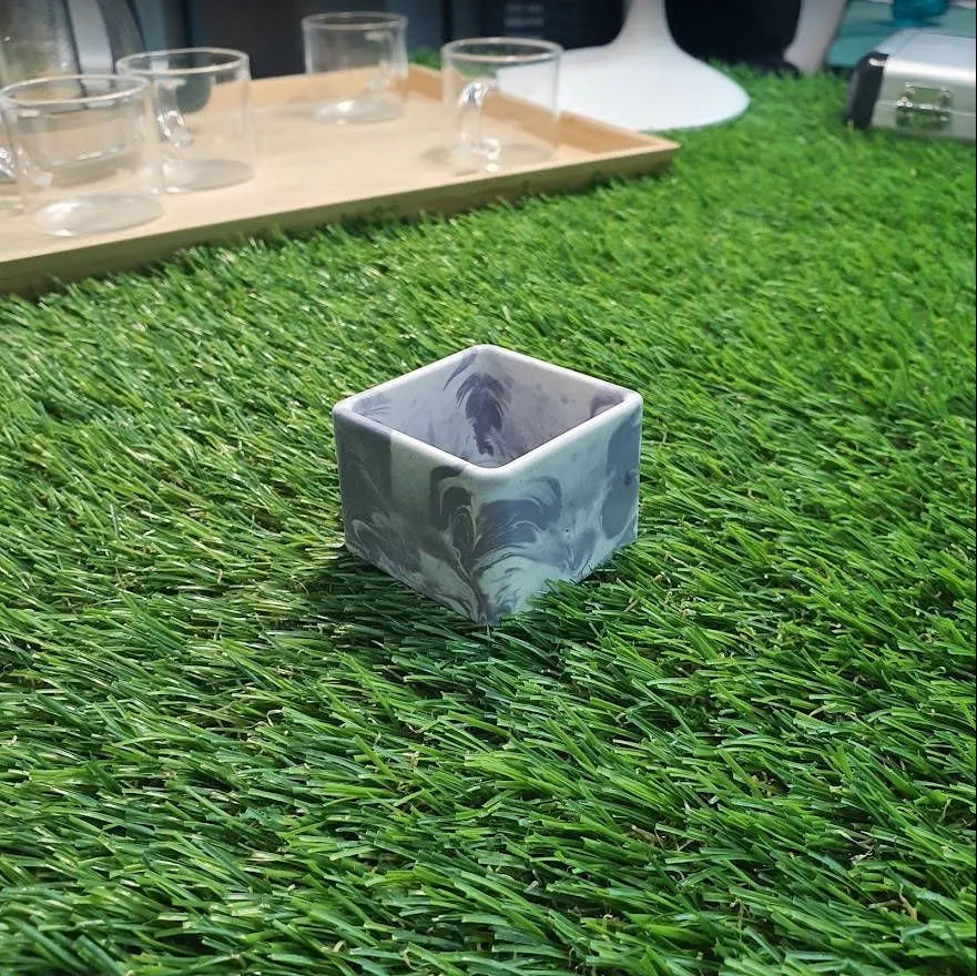 A square Jesmonite planter with blue-grey marble swirls inside and out