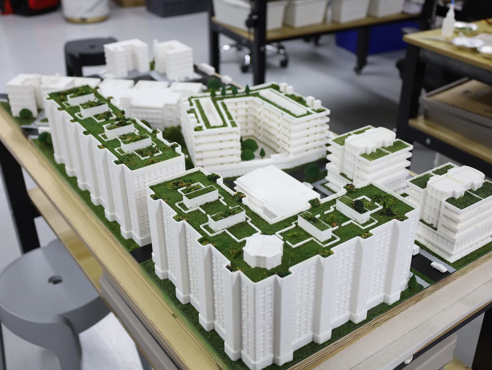 The finished residential district: tall white blocks with green roof gardens, a curved block round a courtyard and lower buildings beyond