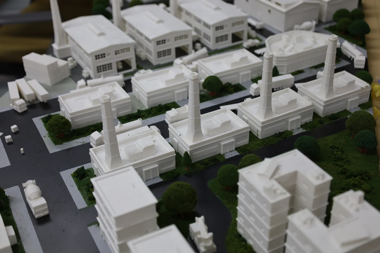The finished industrial district: low factory buildings with tall chimneys, sheds with arched roofs, trucks and trees