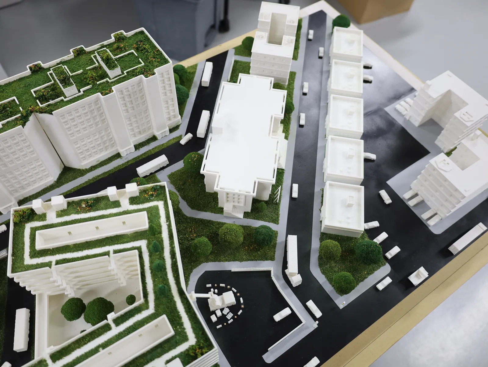 The residential district from above: green-roofed blocks, a row of white buildings, buses on the roads and a crane in a turning circle
