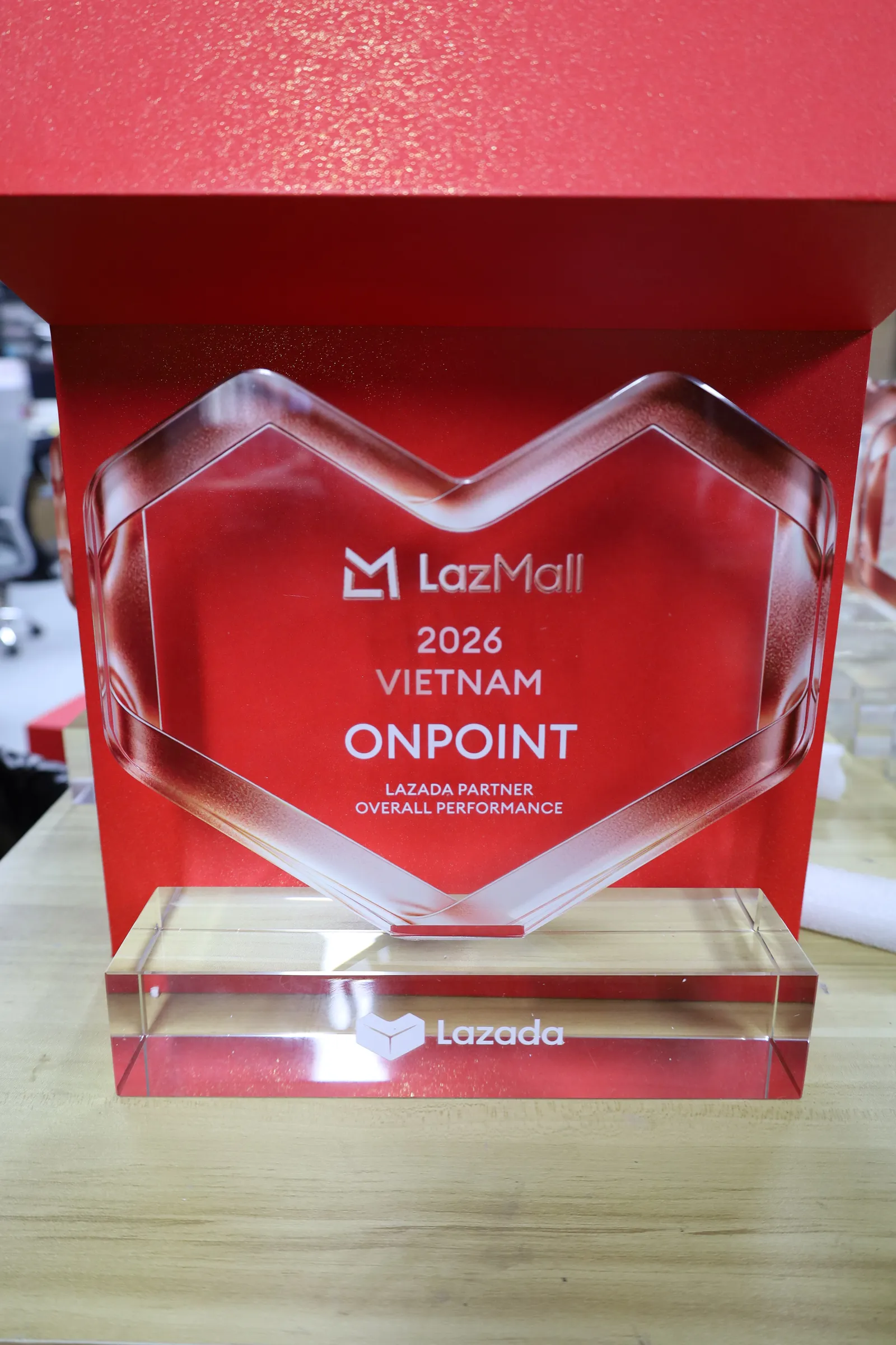 The alternate heart award reading LazMall 2026 Vietnam, Onpoint, Lazada Partner Overall Performance, with the Lazada logo on its clear base